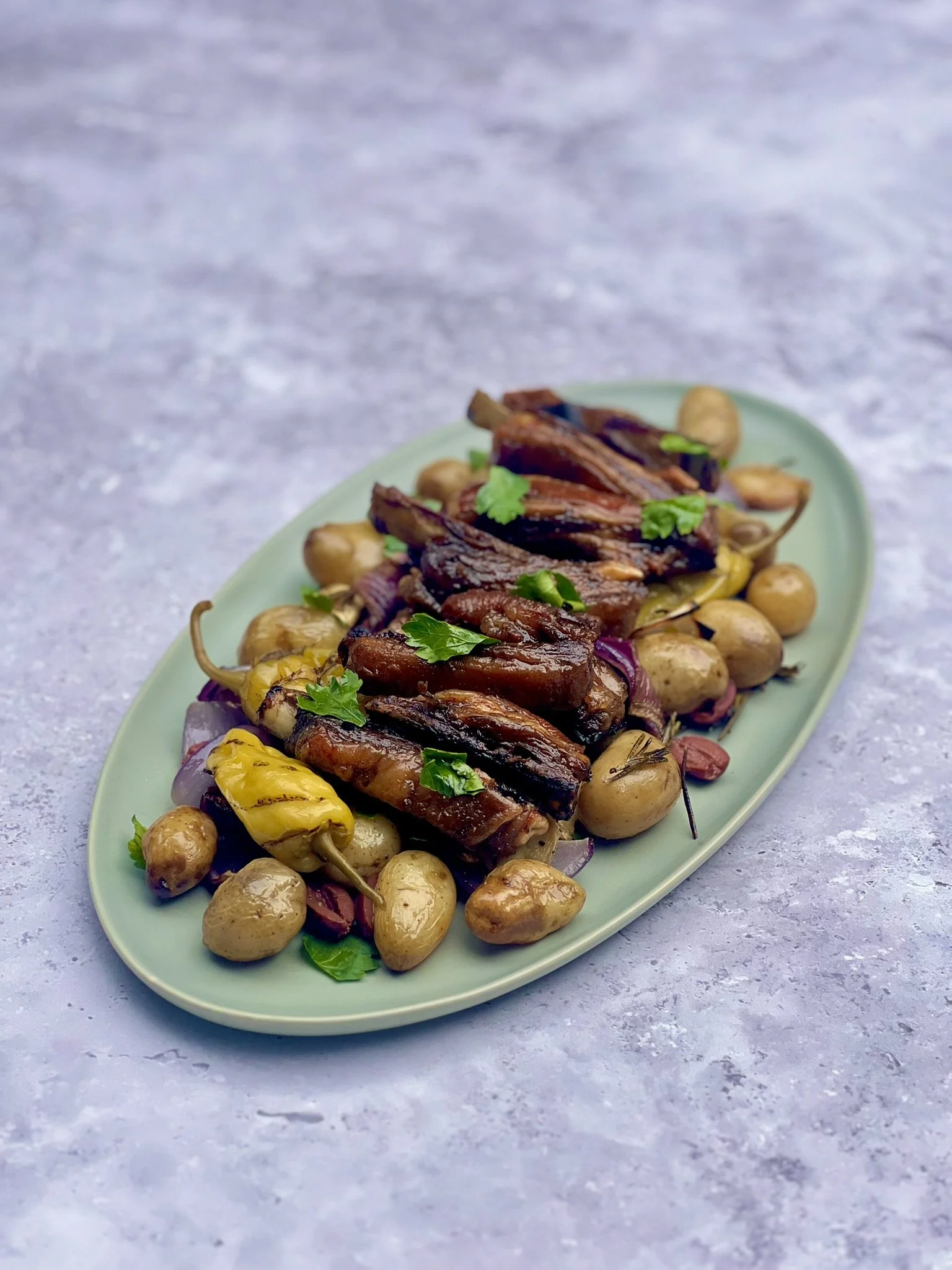 Barbecued Lamb Ribs with Jersey Royals, Black Olives &amp; Pickled Peppers