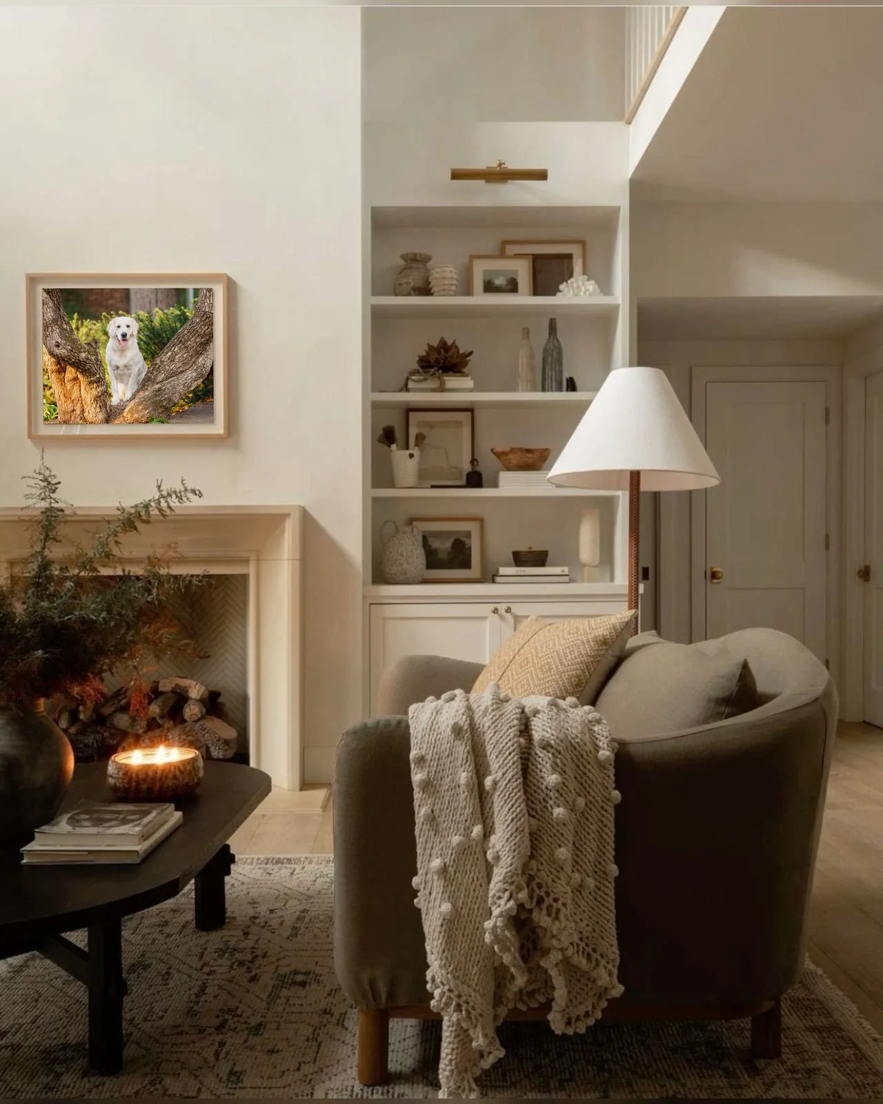 A soft neutral living room with a dog portrait over the mantle showing a cream golden retriever with two paws up on a log at UGA's North Campus in Athens, GA