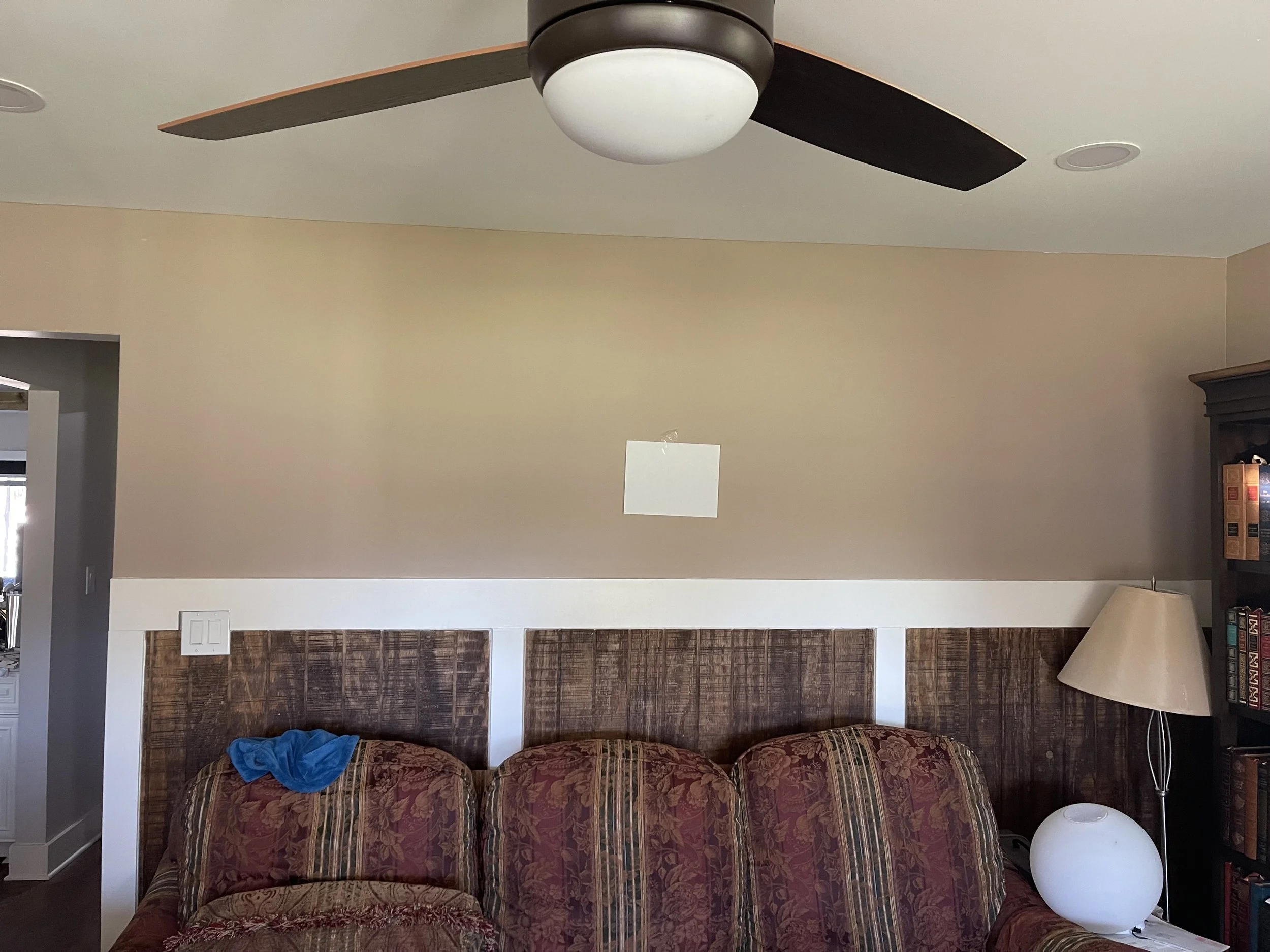 A piece of paper taped above a couch to show scale for Atlanta pet photographer to design custom wall art.