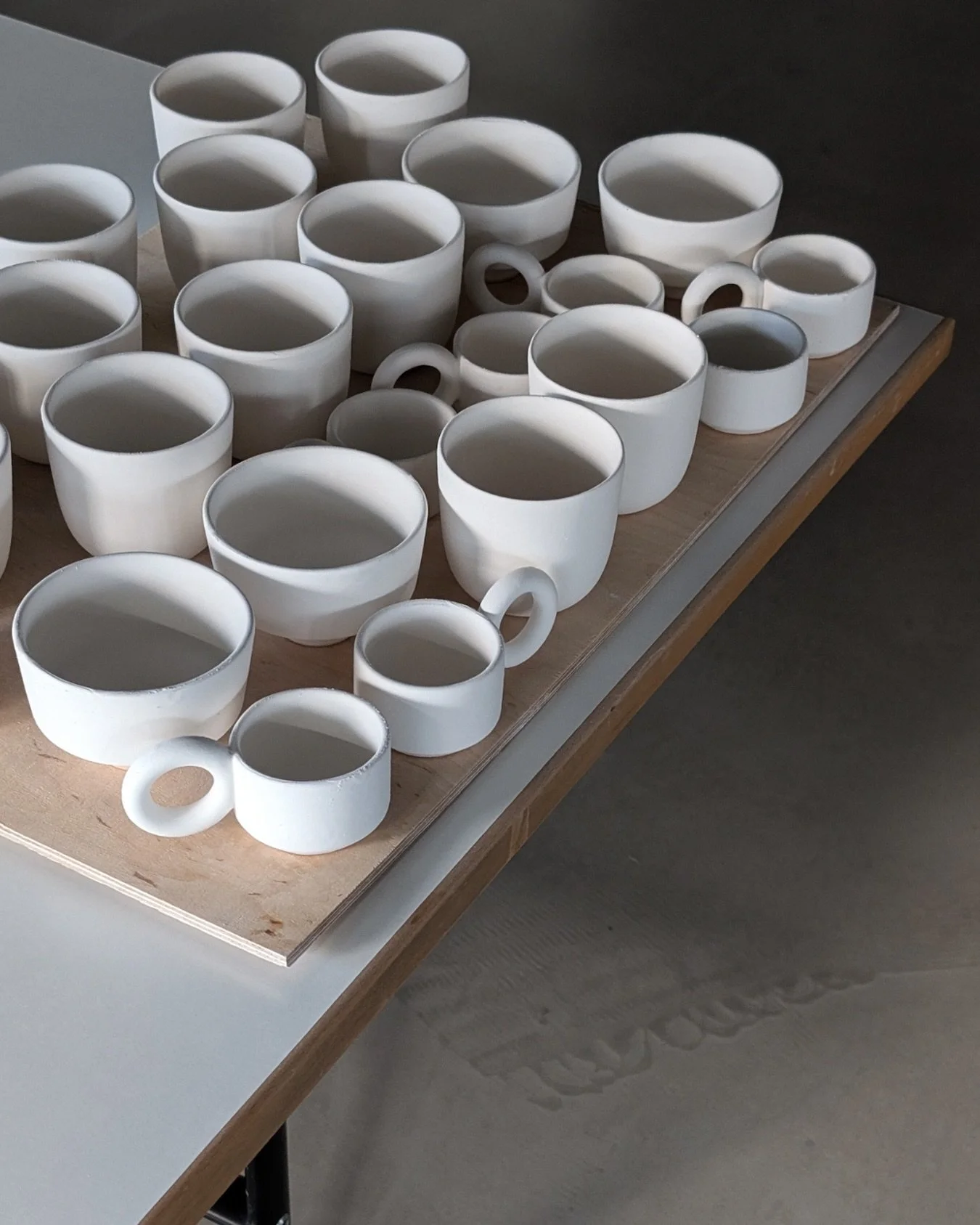 Glazing time!

These cups are actually dipped in a transparent glossy glaze - the final result is so distant from this in-between state. Very fragile and uncertain phase of the ceramic process.

At Chamotte each Member is responsible for glazing thei