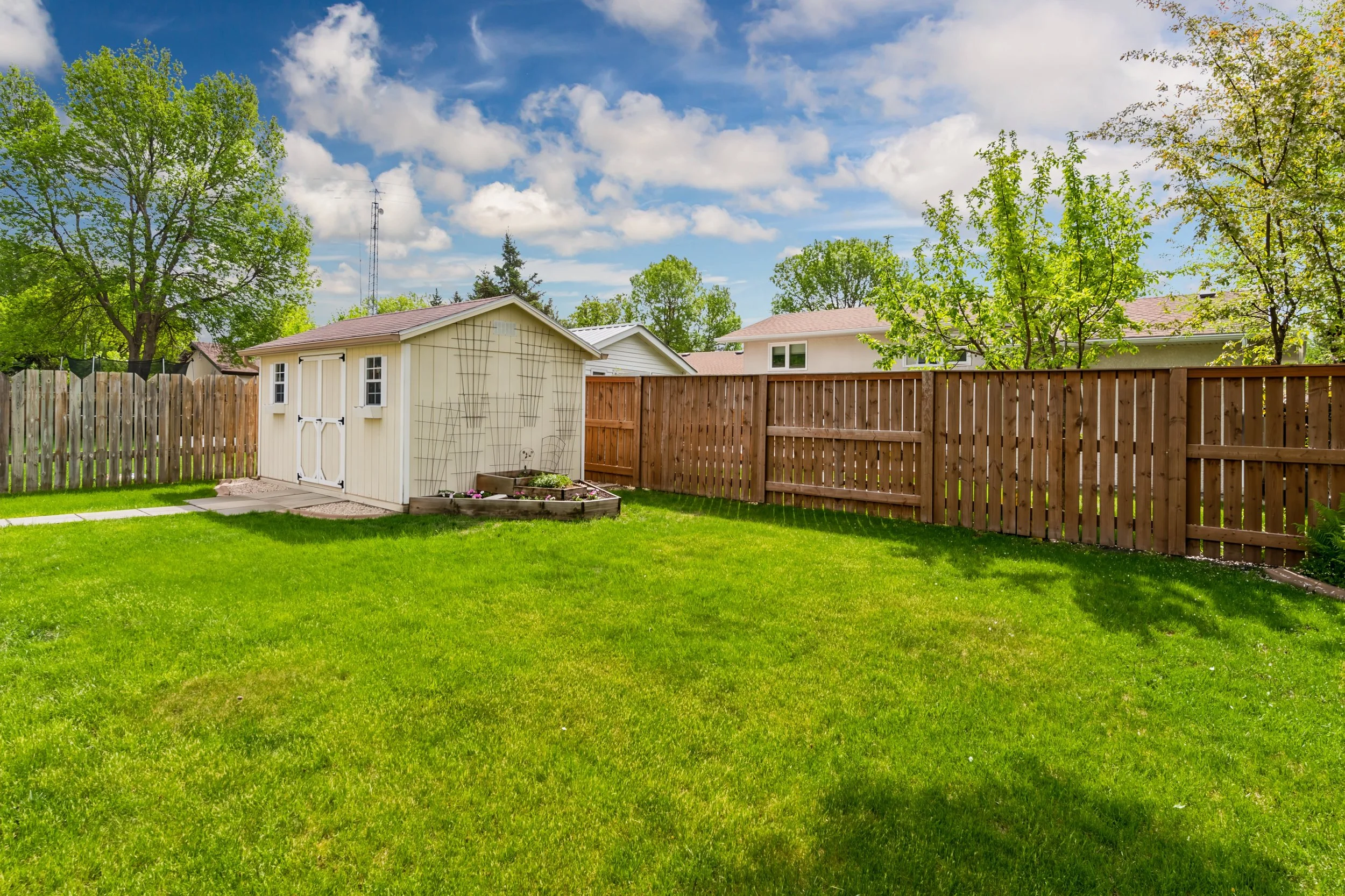044 Family-friendly backyard with deck, shed, and mature landscaping.jpg