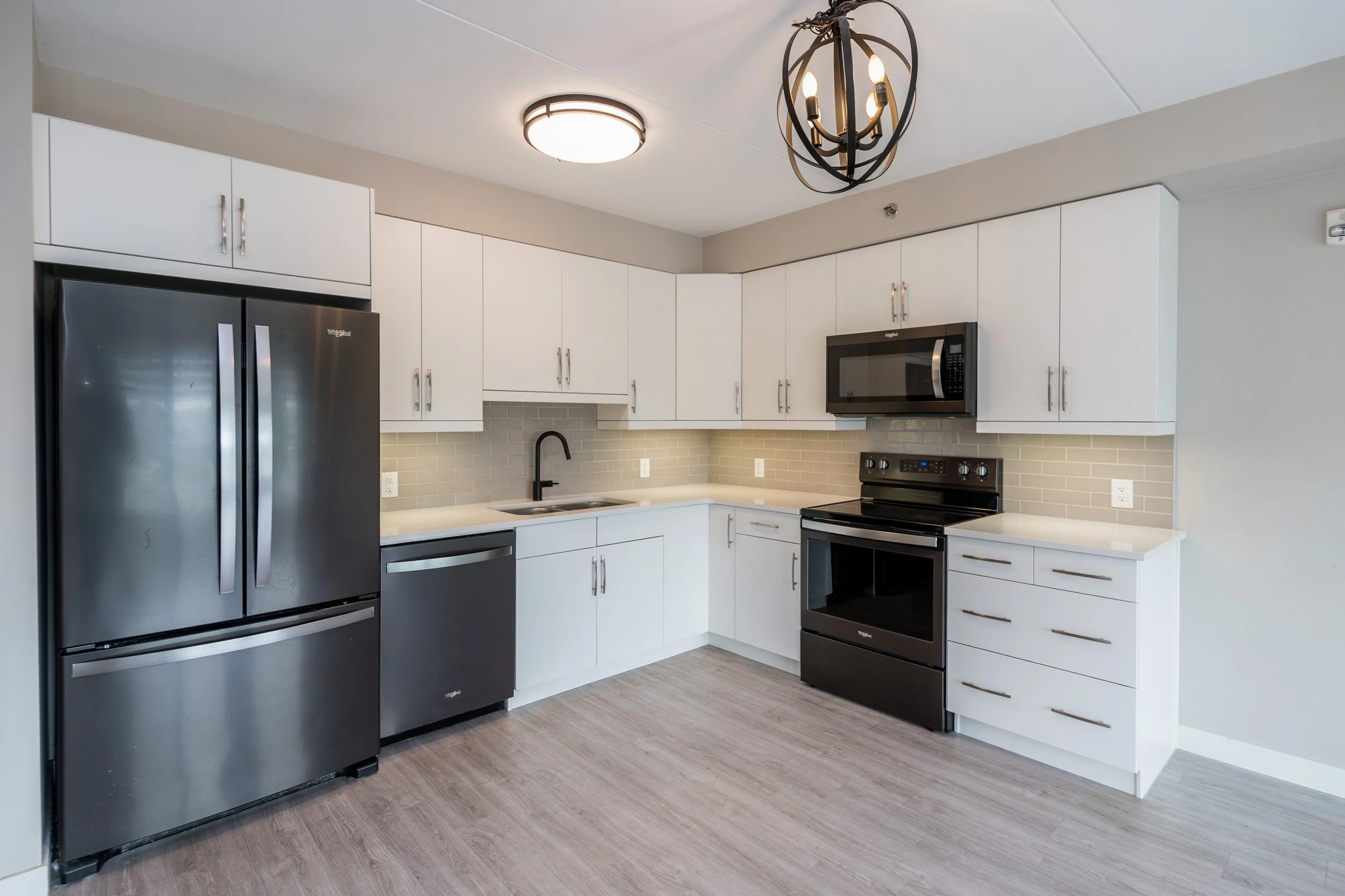 006 Modern kitchen with white cabinetry, quartz countertops and stainless steel appliances.jpg
