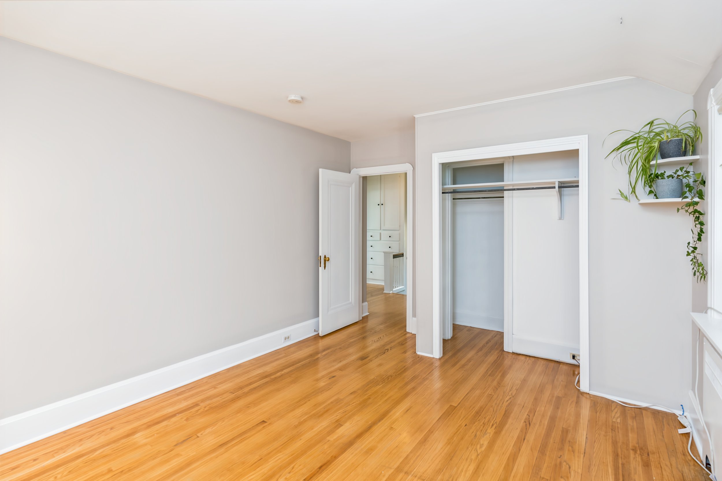 041 Bedroom with hardwood flooring and bright window.jpg