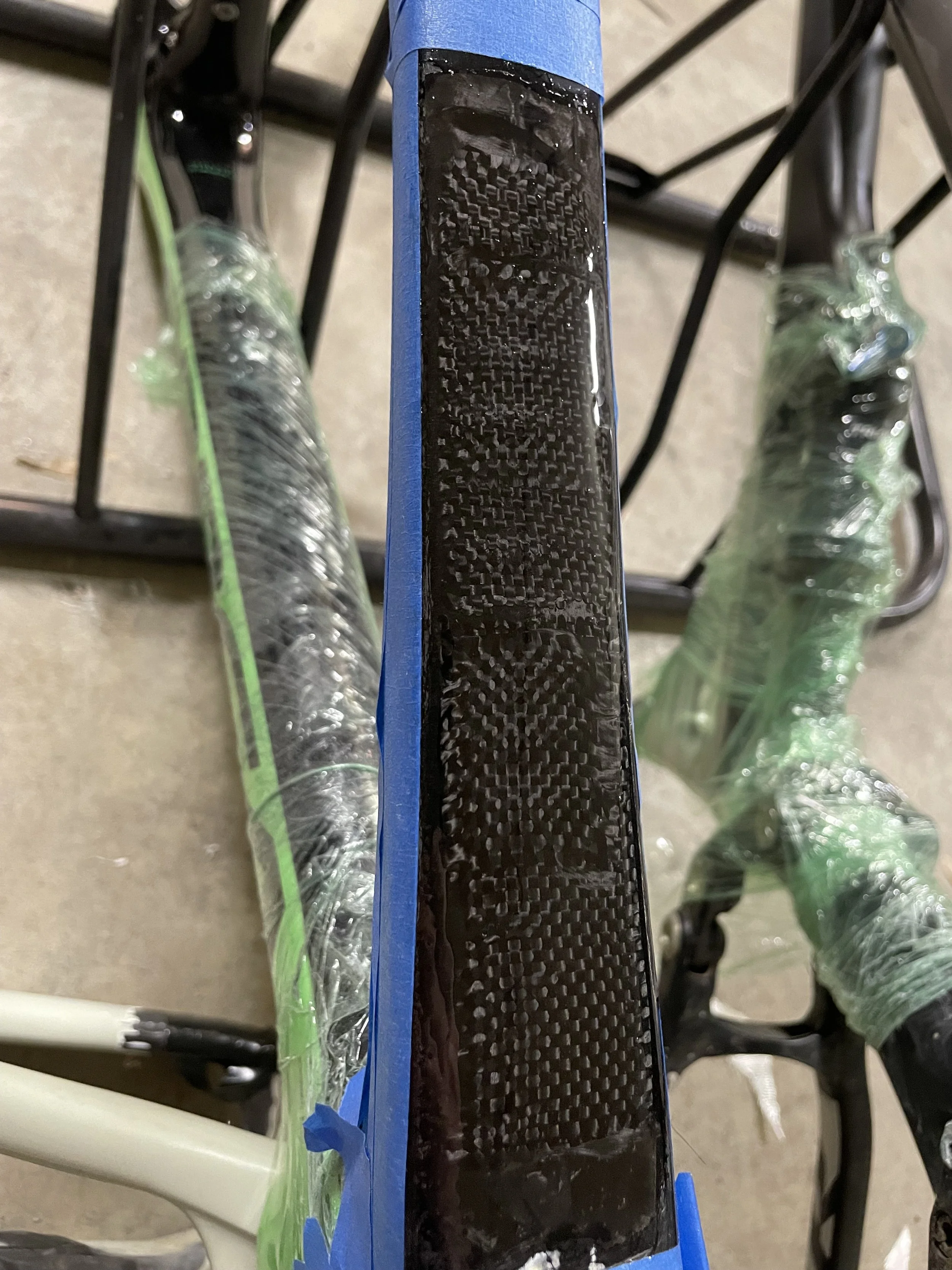 The top tube has been reinforced with bidirectional carbon fiber to add strength and support before drilling holes for the inserts.