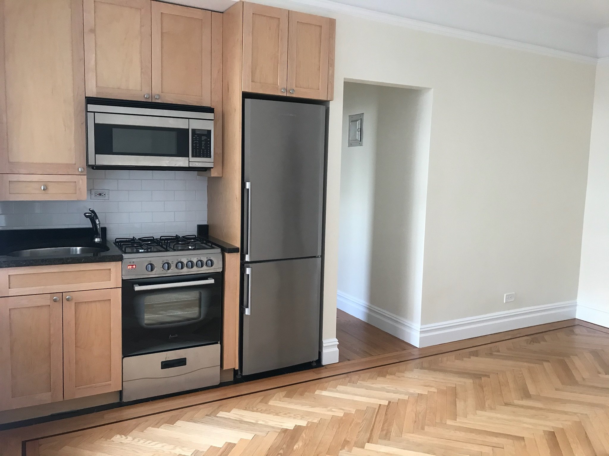 Floor refinishing and detail cleaning in a West Village kitchen. Brought out the natural grain in the herringbone hardwood.