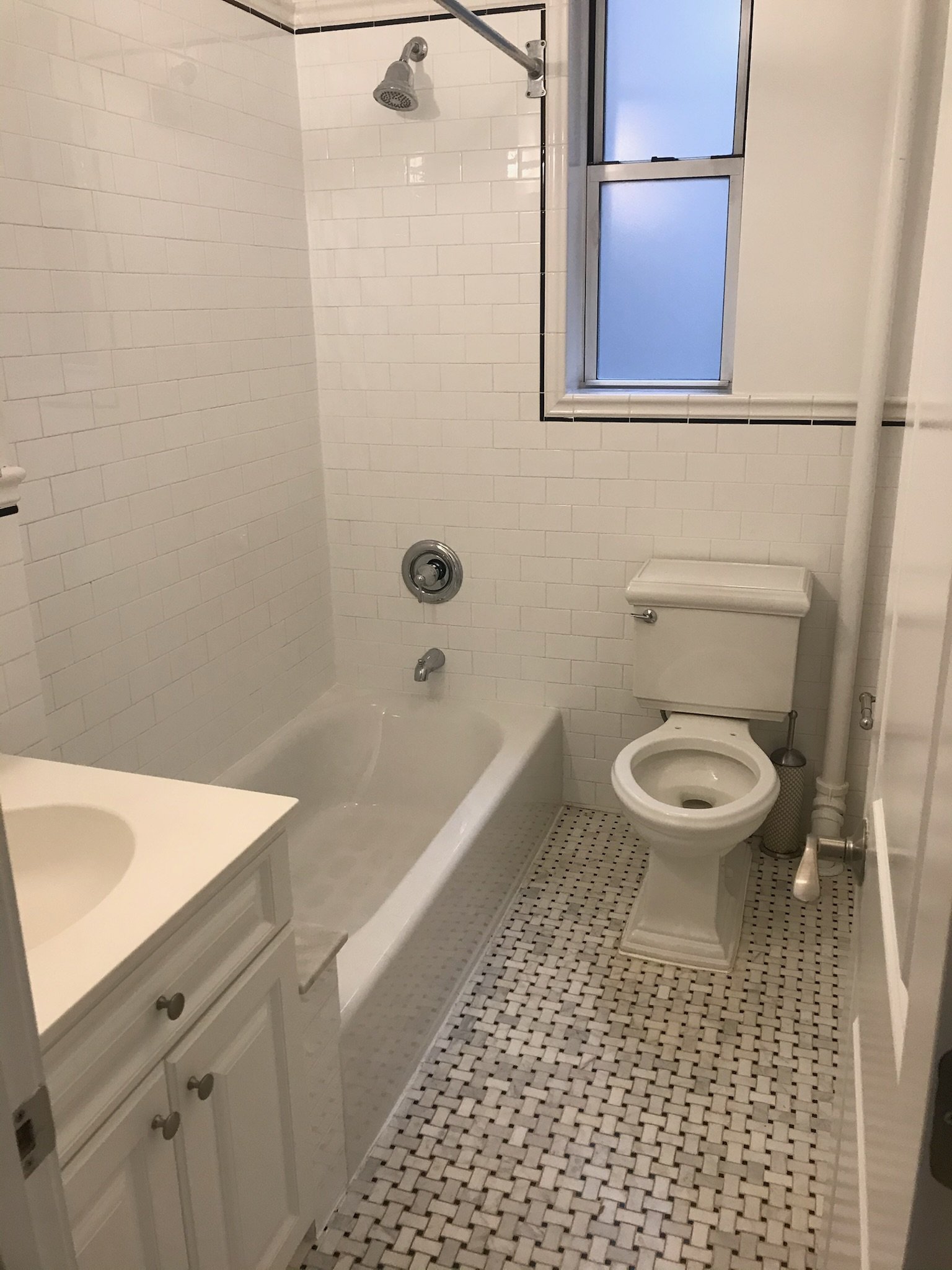 Spot painting, caulk resealing, and tile edge polish in a bright West Village bathroom. Quiet updates, clean results.