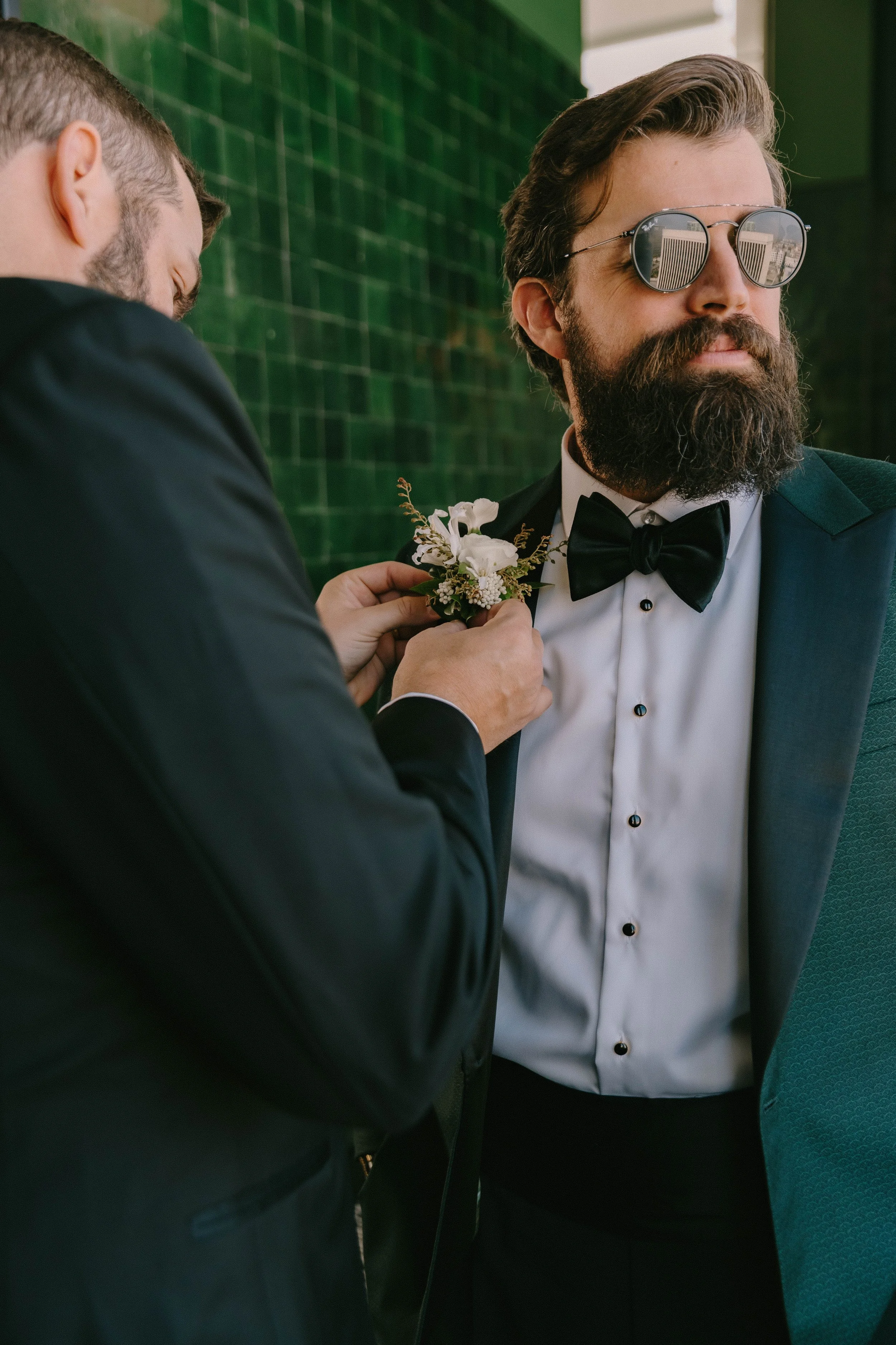 Groom adjusting his boutinere while getting ready at Fairmont Breakers Hotel Long Beach — Long Beach wedding photographer Tesla Rae Photo