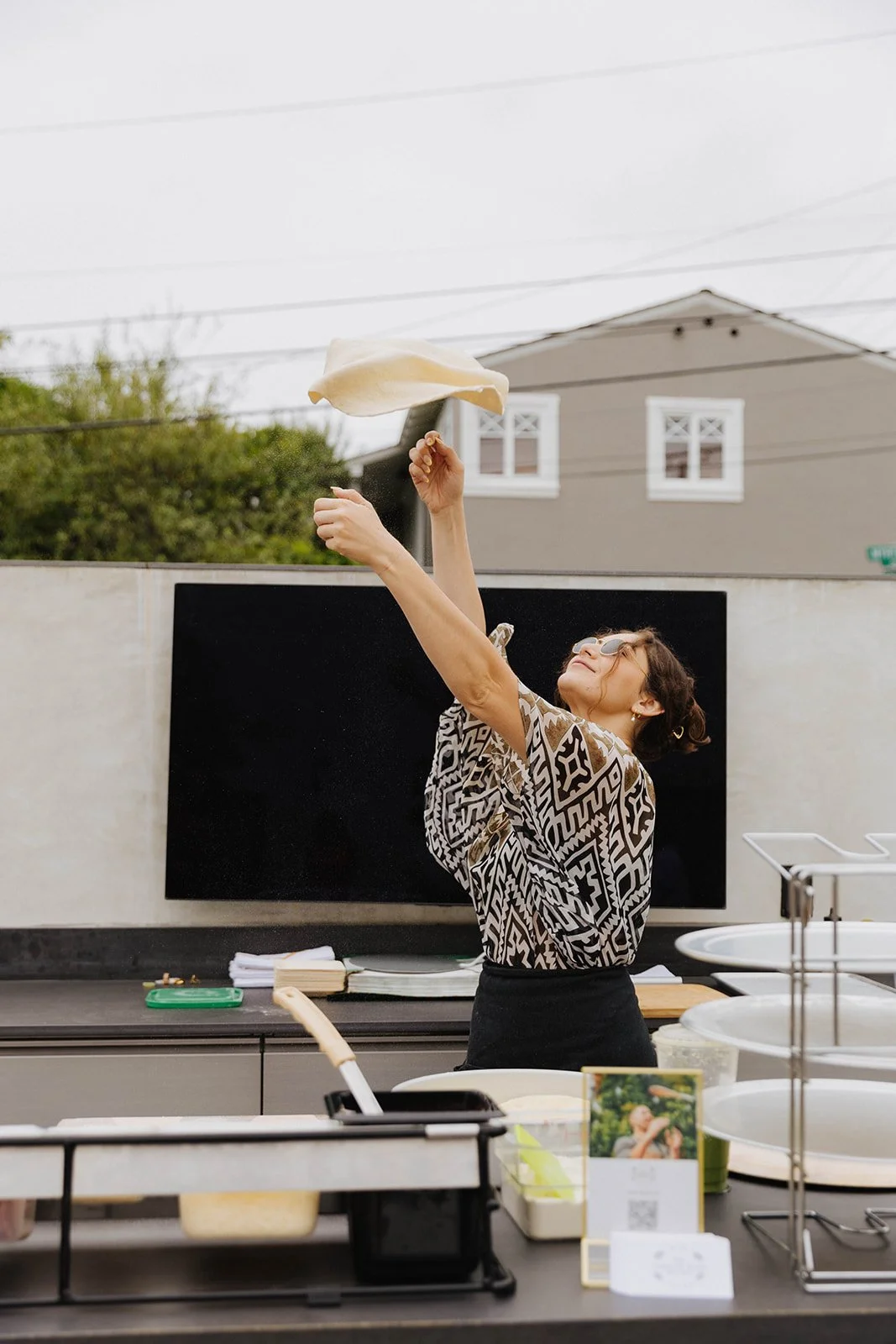Girl flipping homemade pizza at networking event at Bianchi Laguna Beach— Luxury event photographer Tesla Rae Photo based in Southern California