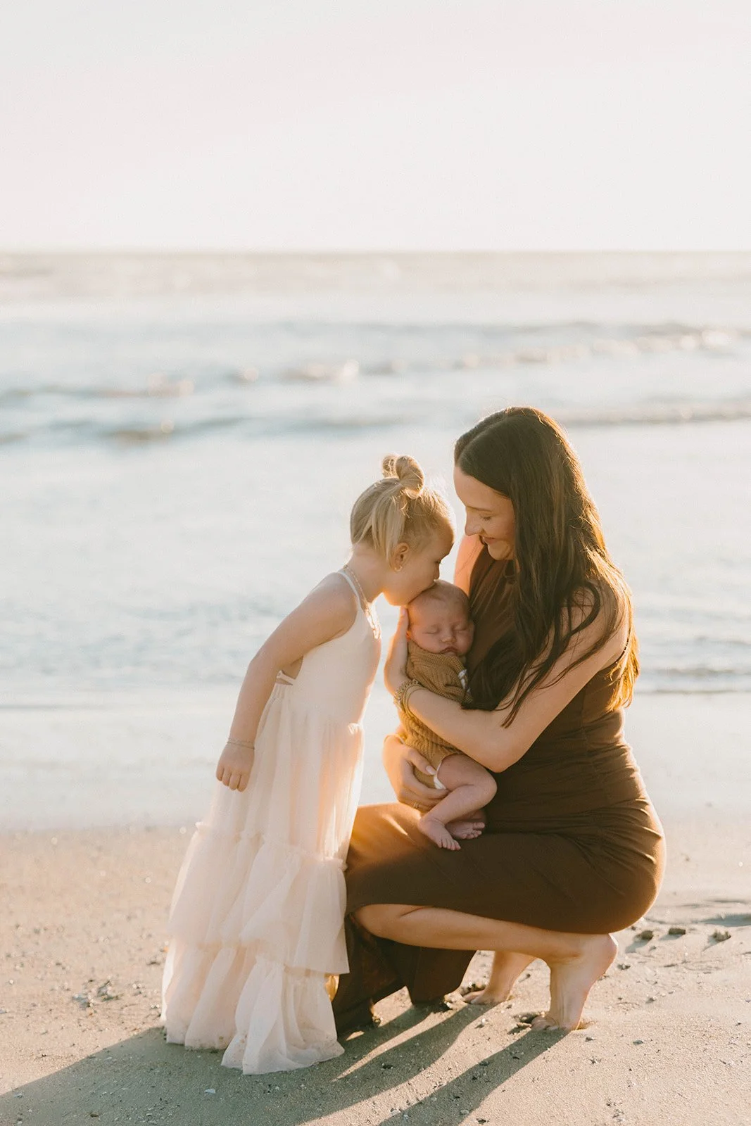 Candid beach family photography session in Laguna Beach featuring playful family connection at sunset with warm coastal tones and natural movement.