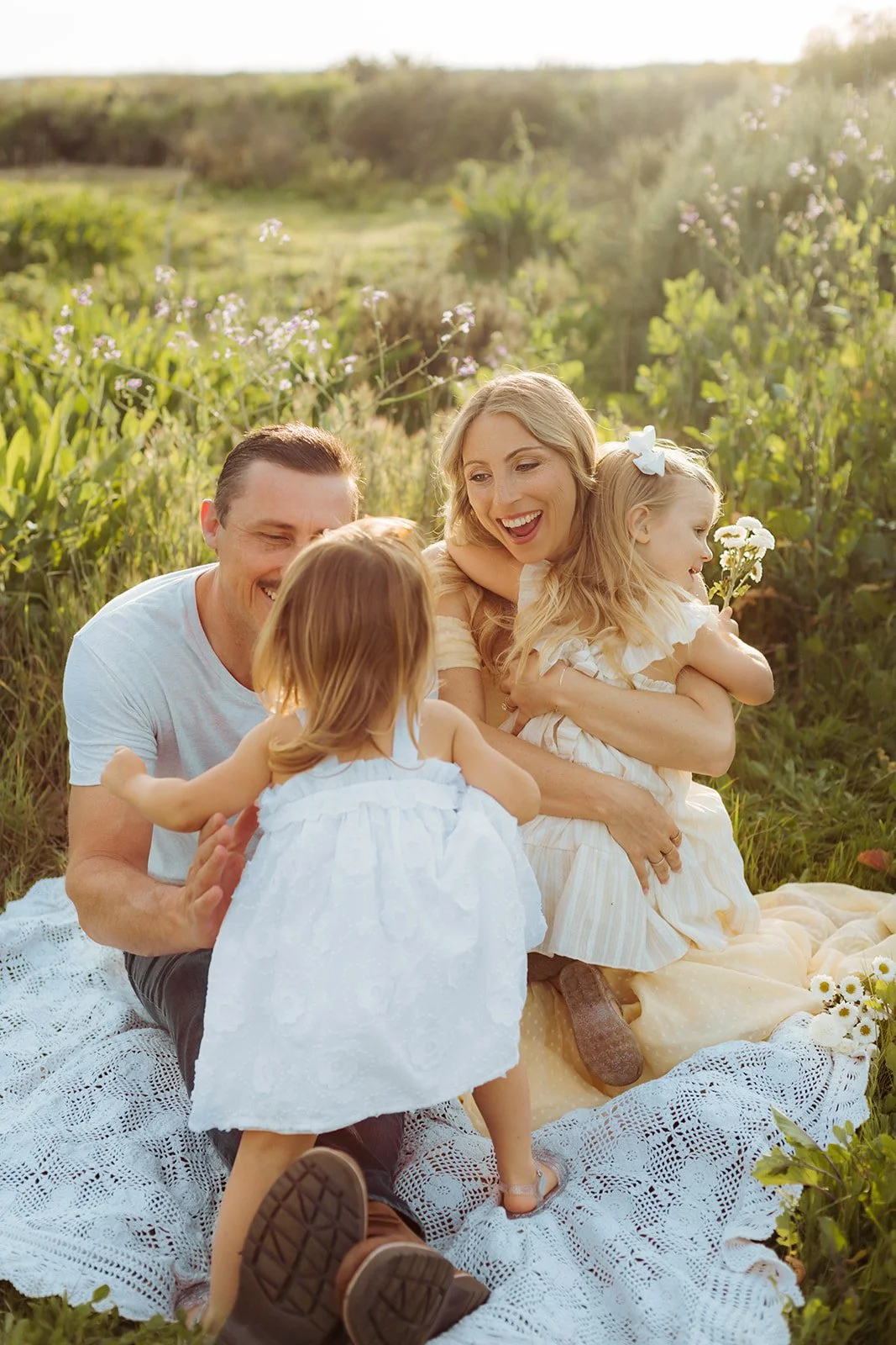 Candid family portrait  with mom laughing at sunset in green, golden field in Costa Mesa — Best maternity photographers in Orange County — Tesla Rae Photo