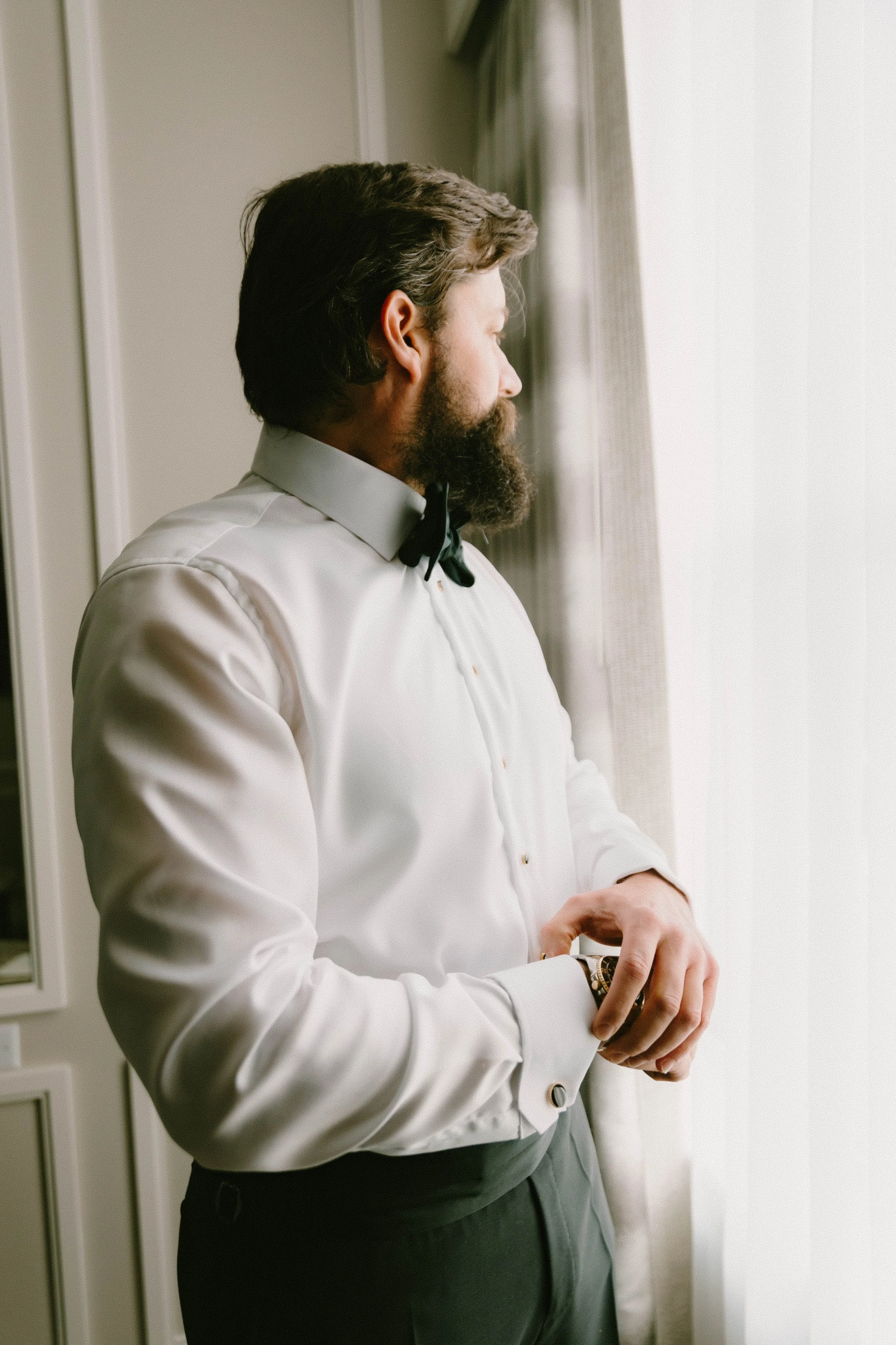Groom adjusting his watch while getting ready at Fairmont Breakers Hotel Long Beach — Long Beach wedding photographer Tesla Rae Photo