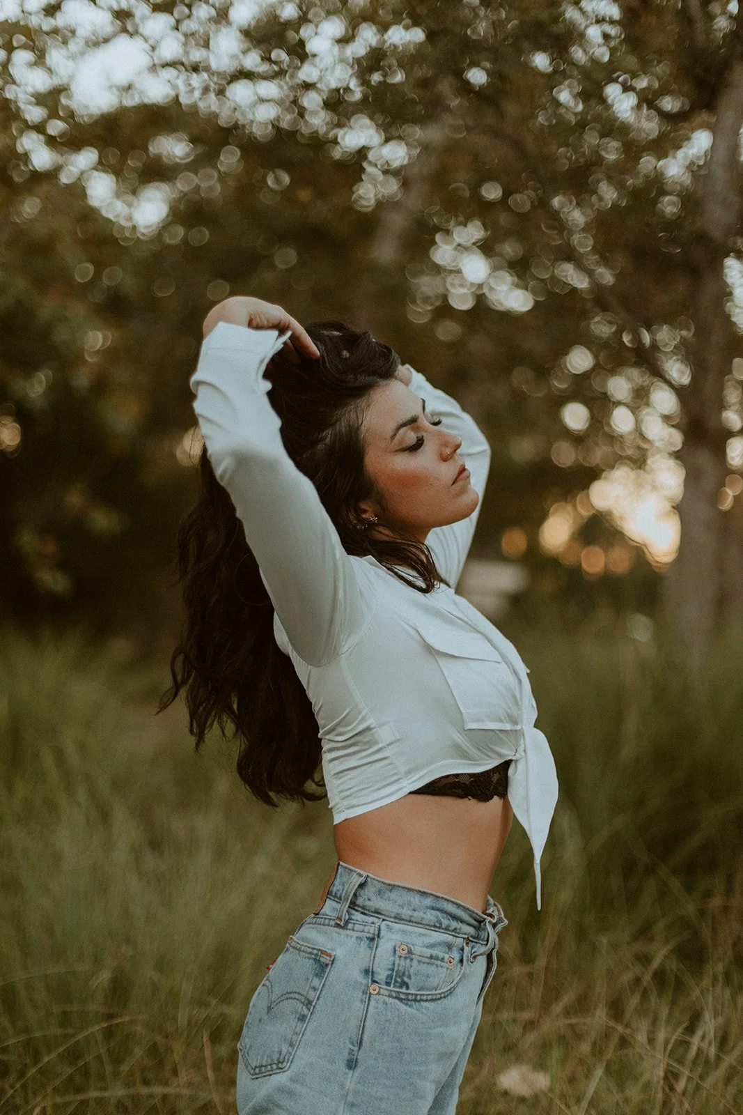 Young woman posing with eyes closed in a grassy field at golden hour — Dreamy lifestyle portrait session in Orange County — Captured by Tesla Rae Photo