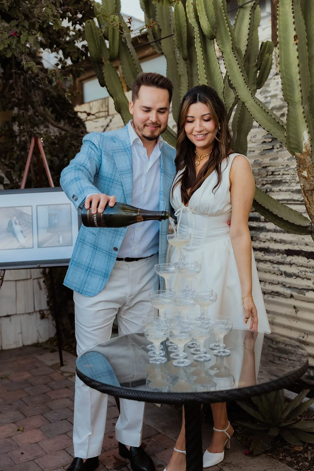 A couple pouring champagne on a champagne tower during couples engagement party at The Shindy in Costa Mesa— Orange County event photographer Tesla Rae Photo