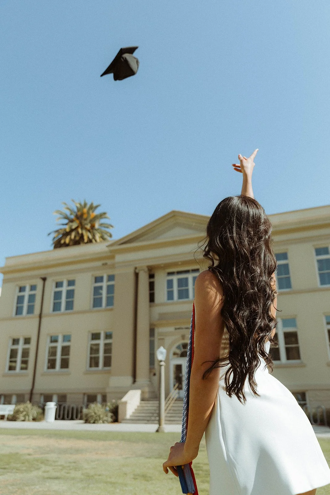 Grad celebrating with lifestyle portraits on Chapman University campus in Orange — Best graduation photographers in Orange County for authentic moments — Captured by Tesla Rae Photo
