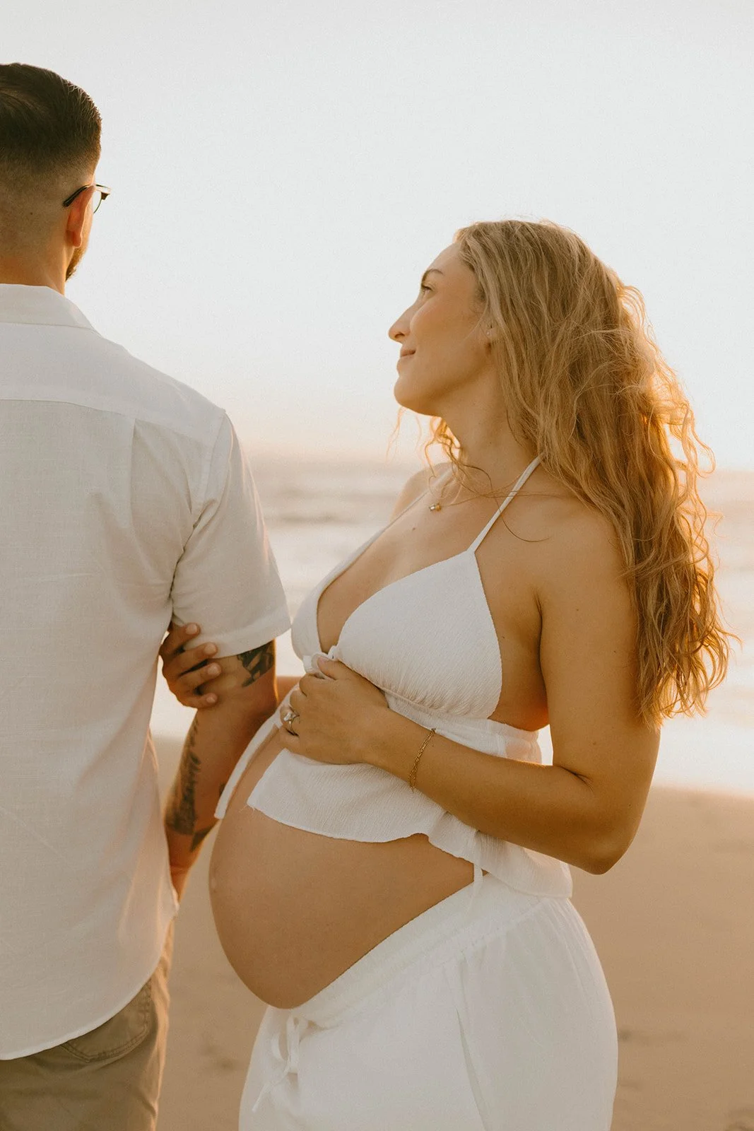 Carefree family laughing and playing during maternity session at Huntington Beach — Best candid family photographers in Huntington Beach — Captured by Tesla Rae Photo