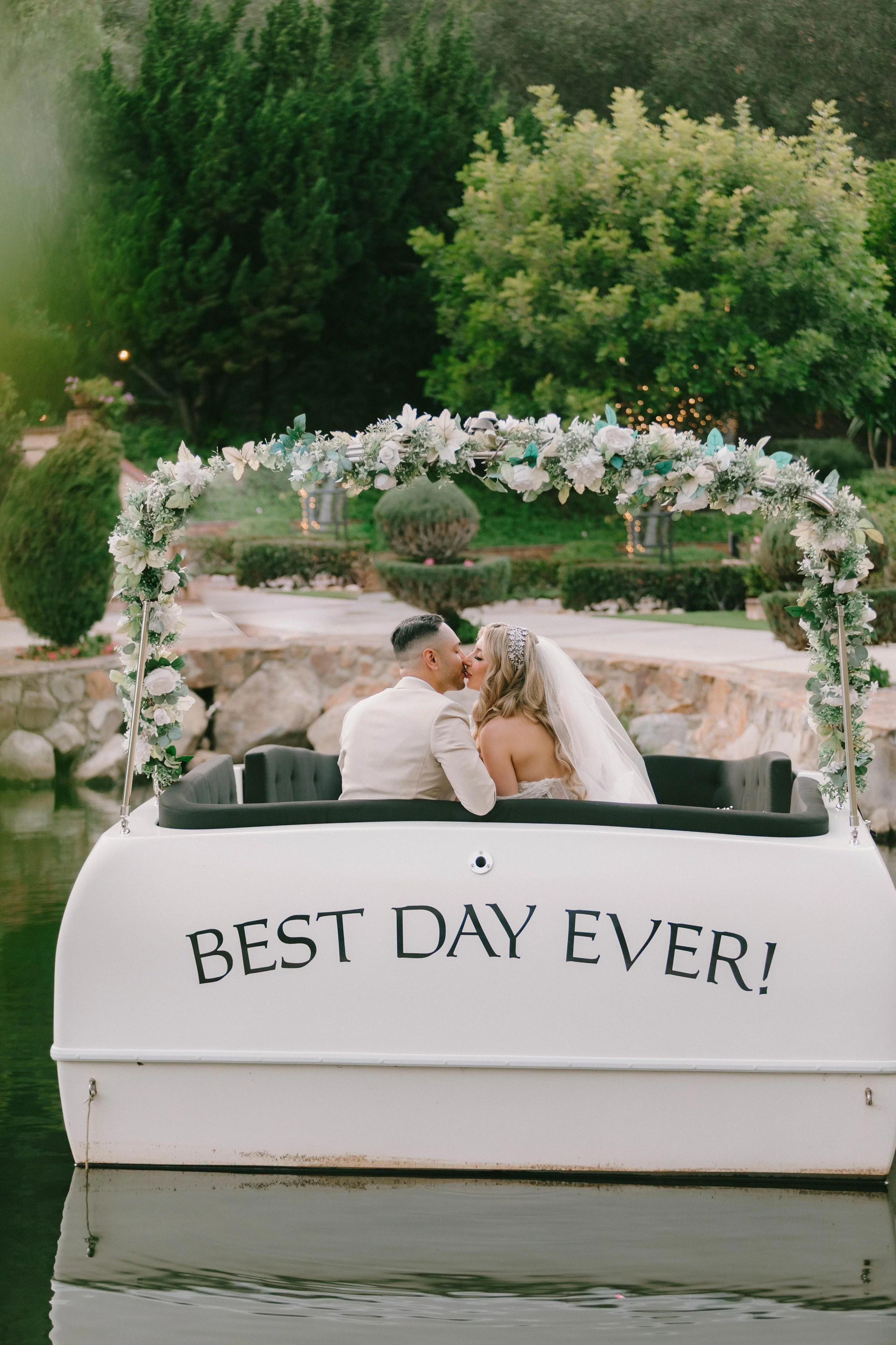 Los Willows Wedding in San Diego. Wedding couple in boat as newlyweds sharing their first kiss.