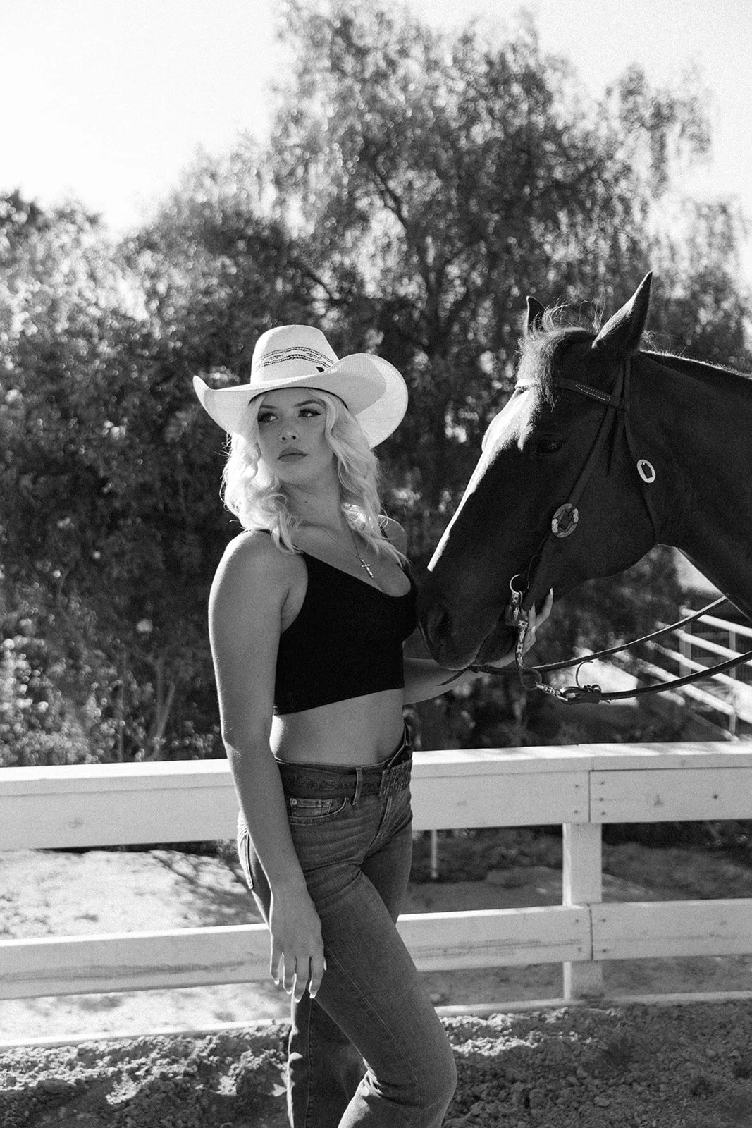 Black and white photo of girl in cowboy hat holding her horse at the horse stables in Huntington Beach— Best brand photographers in Huntington Beach — Captured by Tesla Rae Photo