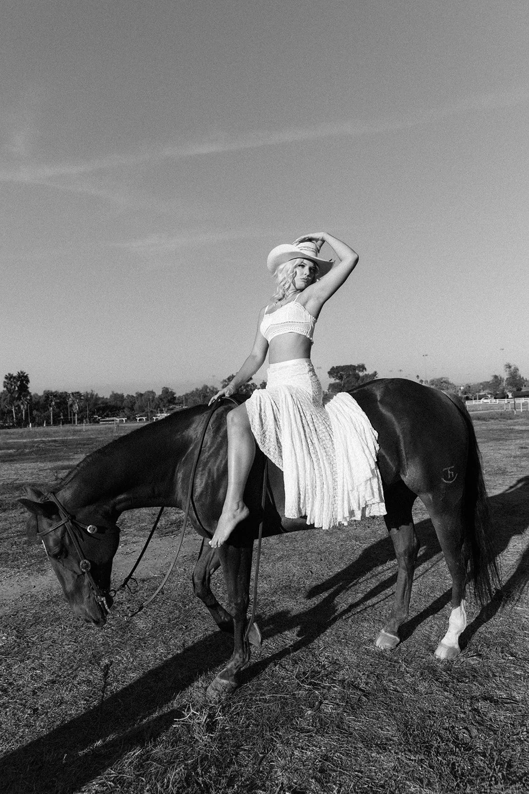 Black and white photo of girl in cowboy hat holding her horse at the horse stables in Huntington Beach— Best brand photographers in Huntington Beach — Captured by Tesla Rae Photo