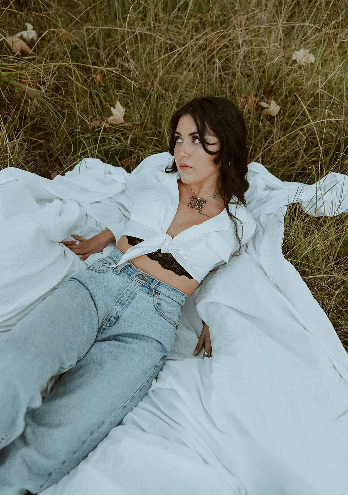 Young woman posing on a white sheet in a grassy field at golden hour — Dreamy lifestyle portrait session in Orange County — Captured by Tesla Rae Photo