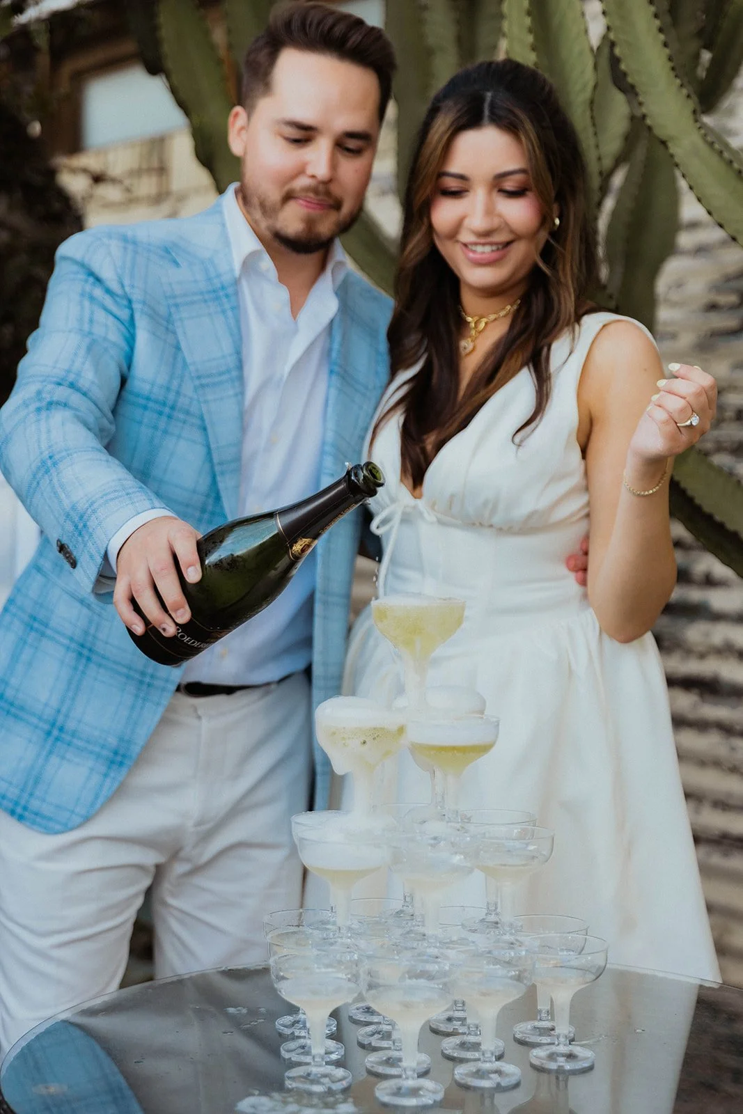A Costa Mesa, CA couple pouring champagne for their guests at their engagement party located at The Shindy.