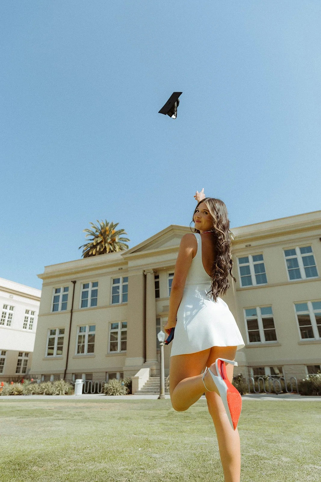 Grad celebrating with lifestyle portraits on Chapman University campus in Orange — Best graduation photographers in Orange County for authentic moments — Captured by Tesla Rae Photo