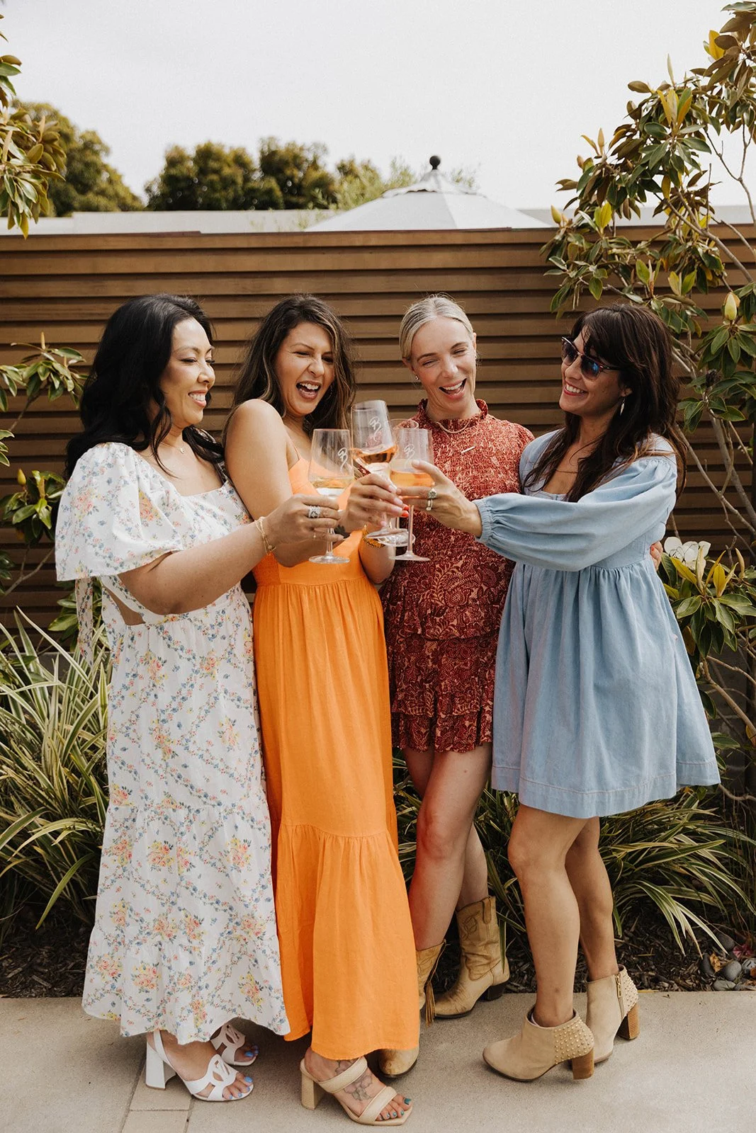 A group of women cheering champagne glasses at an elevated event in Laguna Beach, CA.