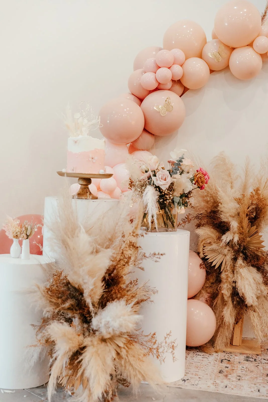 
Elegant floral centerpiece with ballon arch in the background and gorgeous cake at high-end baby shower at Fullerton Arboretum