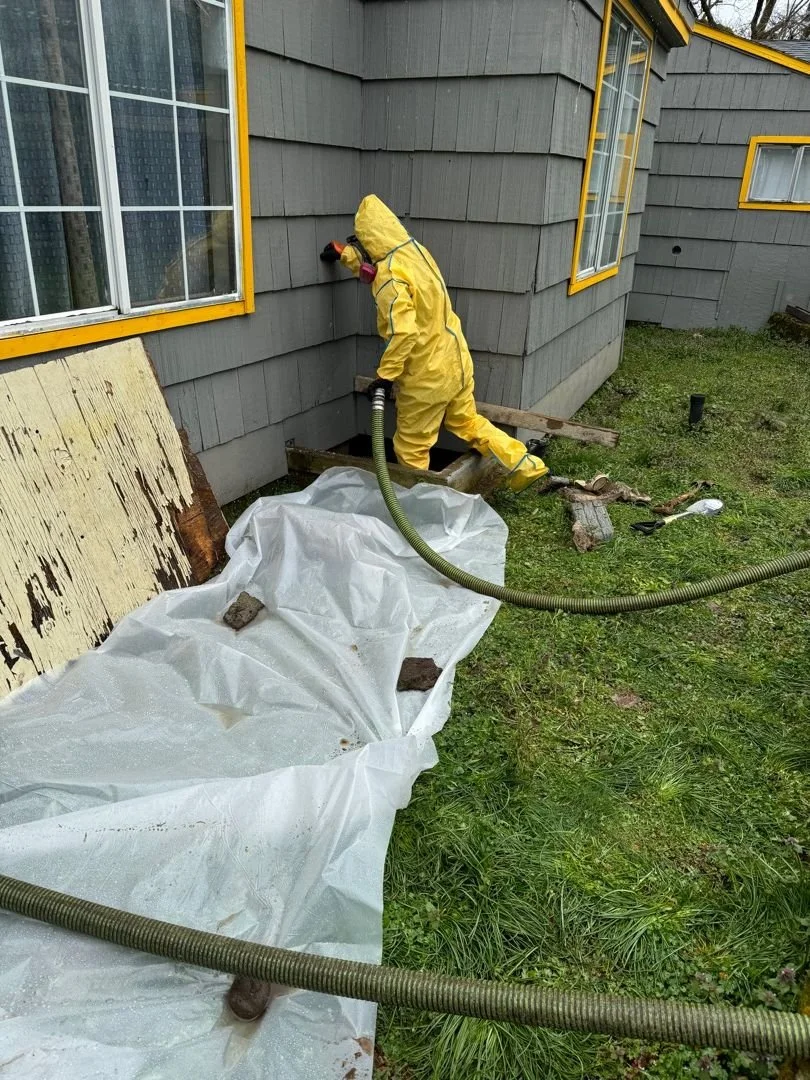 Person in yellow protective suit uses a hose for extraction of sewage cleanup vancouver wa