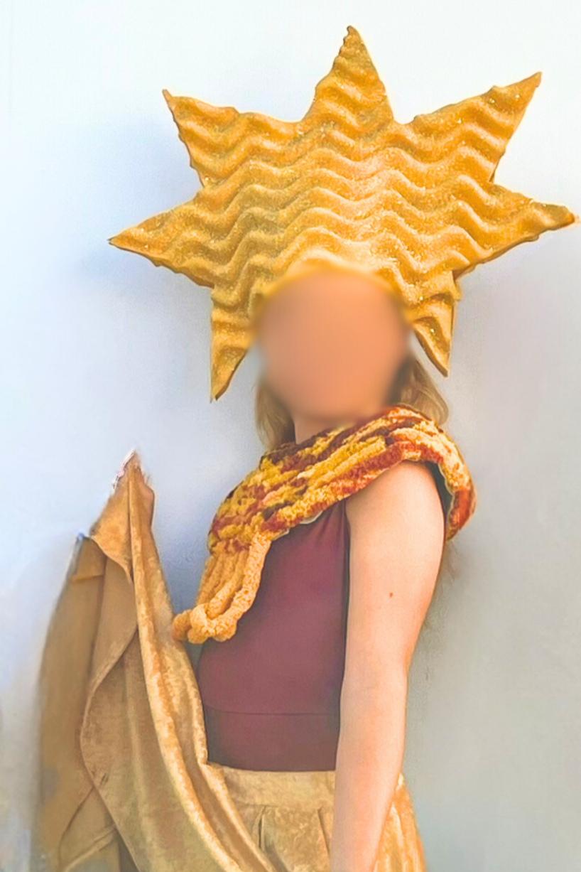 Volunteer-made starfish costume for a youth theater production, featuring a large gold textured starfish headpiece, layered knit scarf in warm tones, sleeveless top, and flowing skirt designed for simple construction and stage movement.