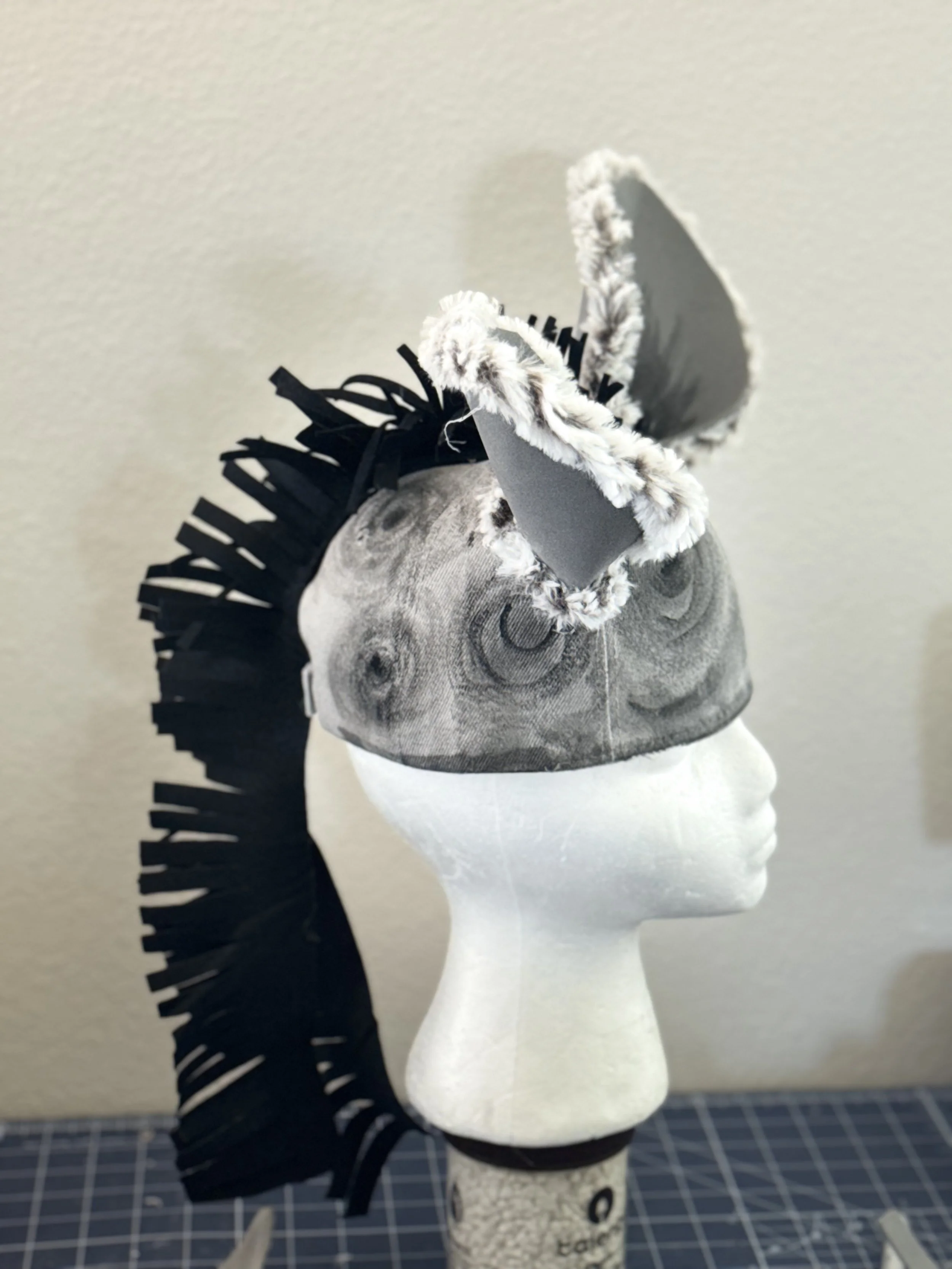 Lion King JR – Hyena  Animal Headpiece: Gray and black faux-fur animal headpiece displayed on a mannequin for a school musical costume.