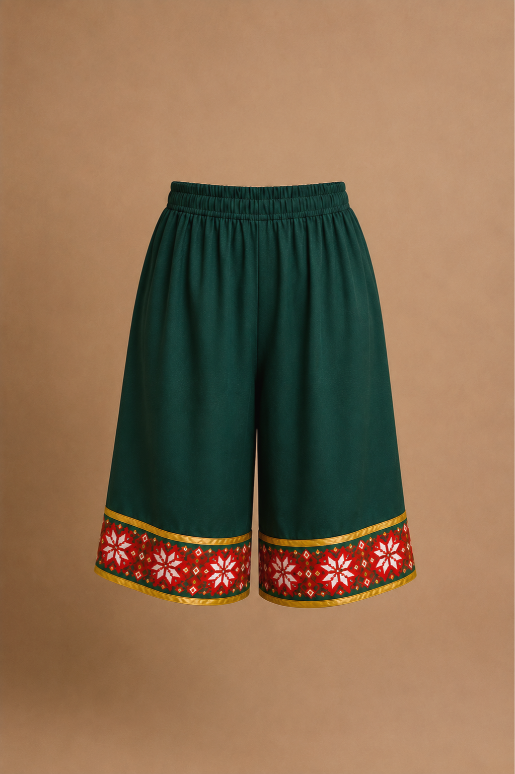 Dark green Elf Jr. the Musical costume shorts with a red and white embroidered hem featuring snowflakes and holiday floral patterns. A budget-friendly DIY piece for school and community theater productions building an old-world elf look for ensemble