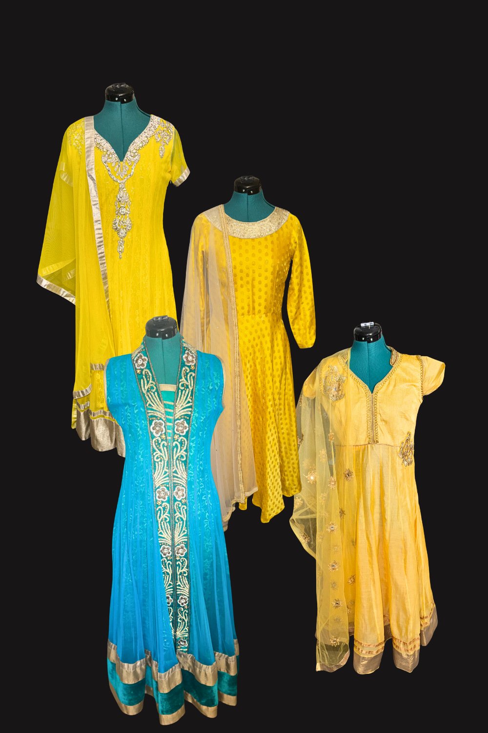 Four mannequins displaying colorful traditional Indian dresses in yellow, blue, and gold with embroidery and embellishments, set against a black background.