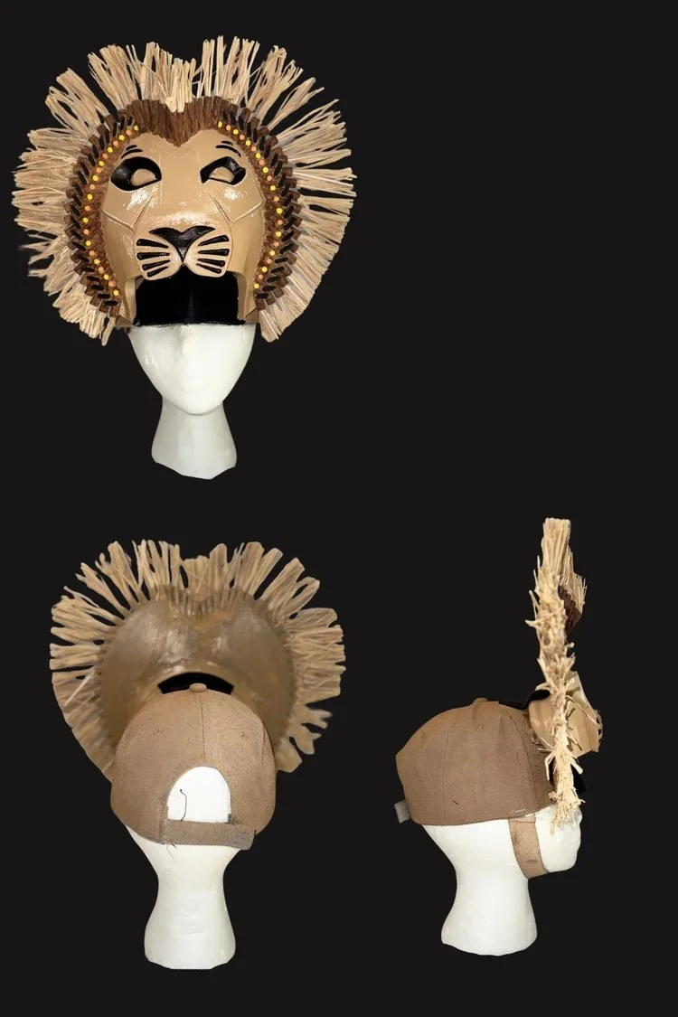 Collection of handmade lion costume masks and headdresses featuring sculpted lion faces, textured manes, and natural-colored materials, displayed on mannequin heads for The Lion King JR.