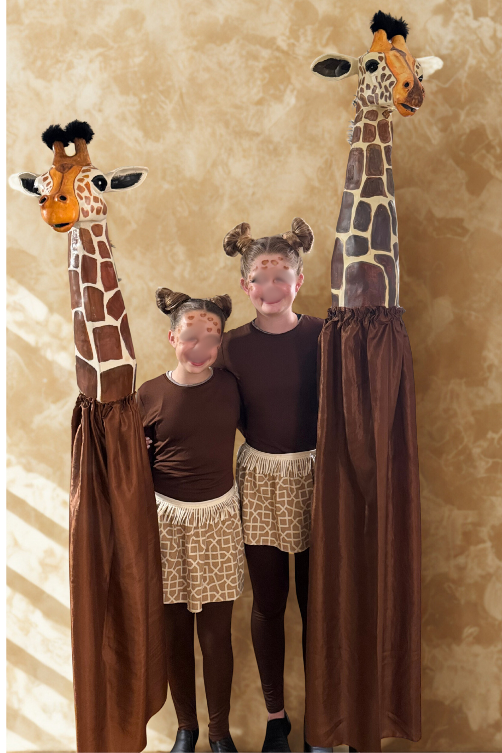 Youth performers wear a DIY giraffe costume for a Lion King JR production, featuring a lightweight paper mâché giraffe head, brown unitard base, and a simple handmade skirt sewn from upholstery fabric for school theater ensembles.