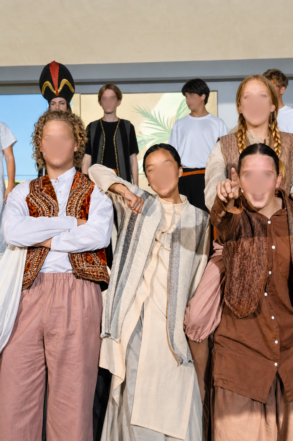 Aladdin and his friends in Aladdin Jr wearing layered Agrabah street costumes with vests, scarves, and relaxed silhouettes during a school musical scene.