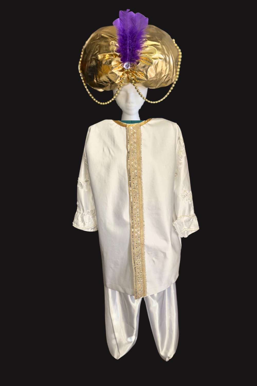Sultan costume for Aladdin JR. A mannequin dressed in traditional Indian attire, including an ornate turban decorated with a purple feather, gold embellishments, and pearl chains, along with a white kurta and pants with gold accents.