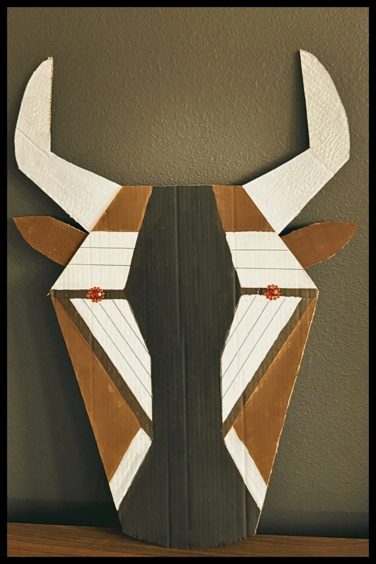 Wildebeest costume- Geometric antelope-inspired animal mask with long horns and angular facial features in brown, black, and white, created for Disney's The Lion King JR.