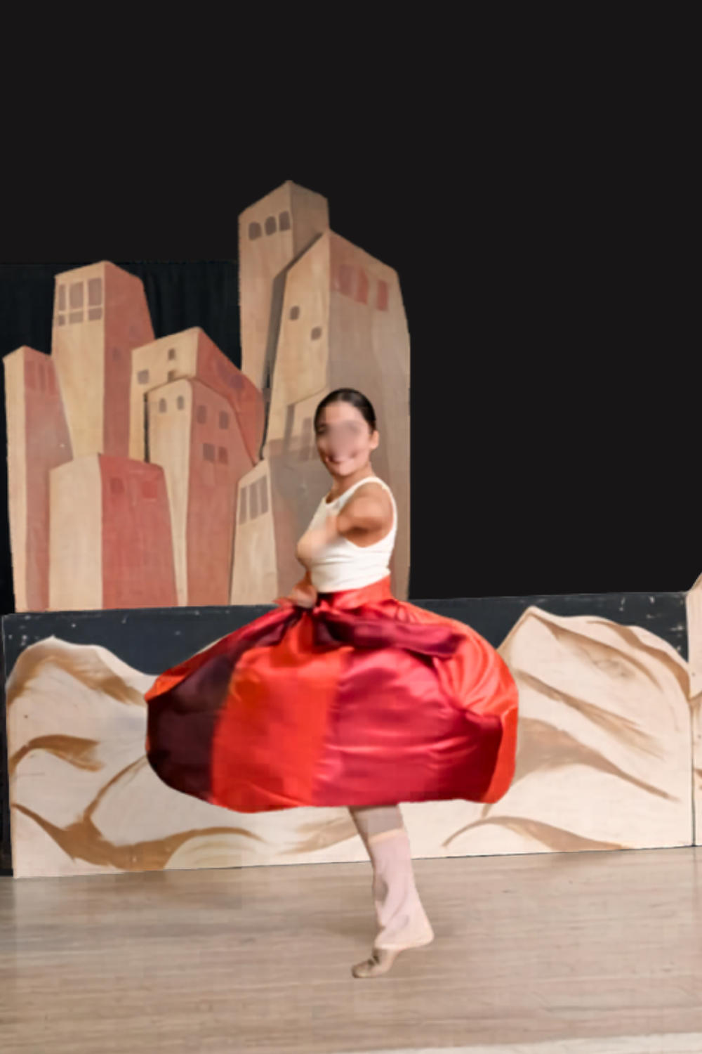 Arabian dancer in Aladdin Jr spinning in a red, orange, brown skirt and white top during a school musical performance scene.