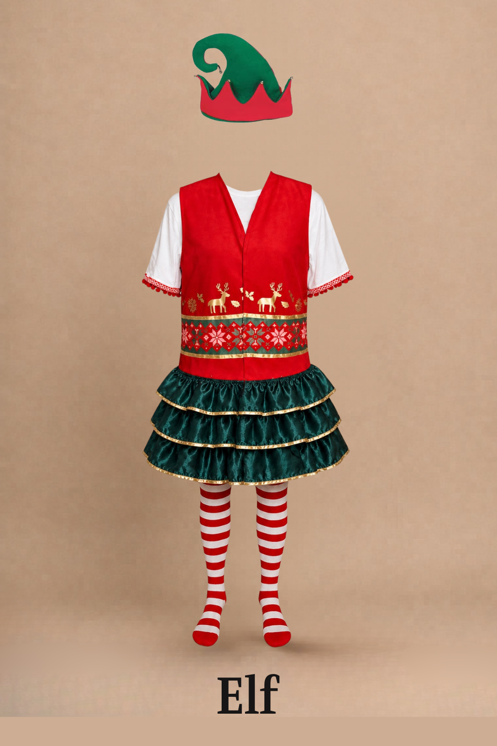 A person dressed as an elf with a jester hat, wearing a red vest with Christmas-themed embroidery, a layered green ruffled skirt with gold trim, striped red and white tights, and standing against a plain beige background. Elf the Musical