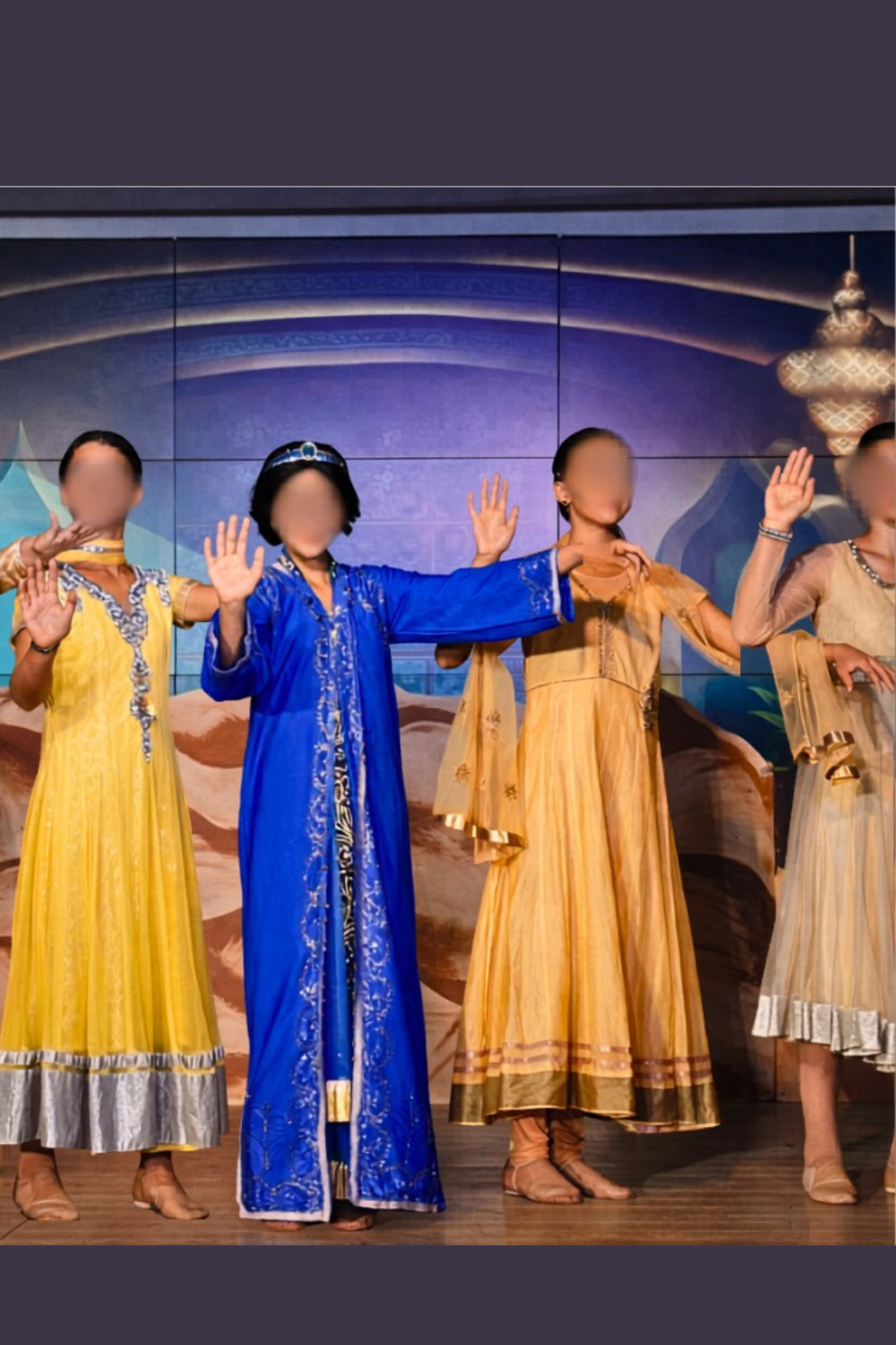Jasmine and friends in blue and yellow costumes during a school musical dance scene for Aladdin JR.