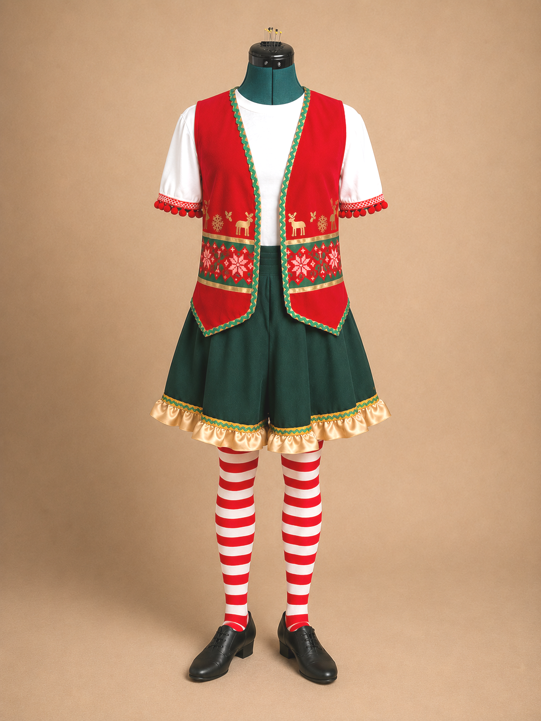 Complete Elf Jr. the Musical costume on a mannequin: a red holiday-patterned vest over a white puffed-sleeve shirt, a dark green gold-trimmed skirt, red and white striped stockings, and black shoes. Full DIY old-world elf ensemble for school theater