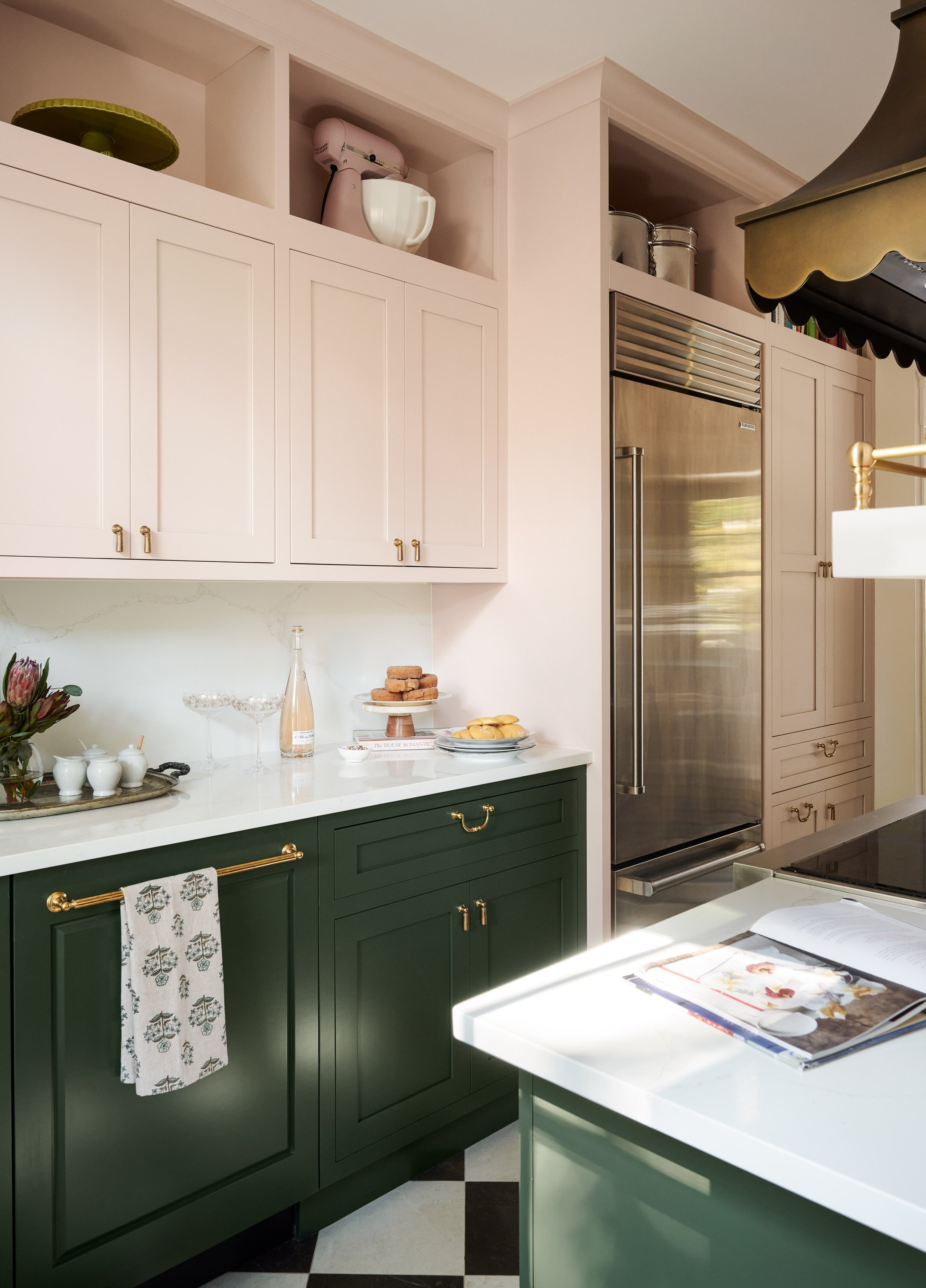 Blush upper cabinets and green lowers with brass hardware and a built-in refrigerator at Summer Street, Newburyport, designed by Ivory & Bone Interiors