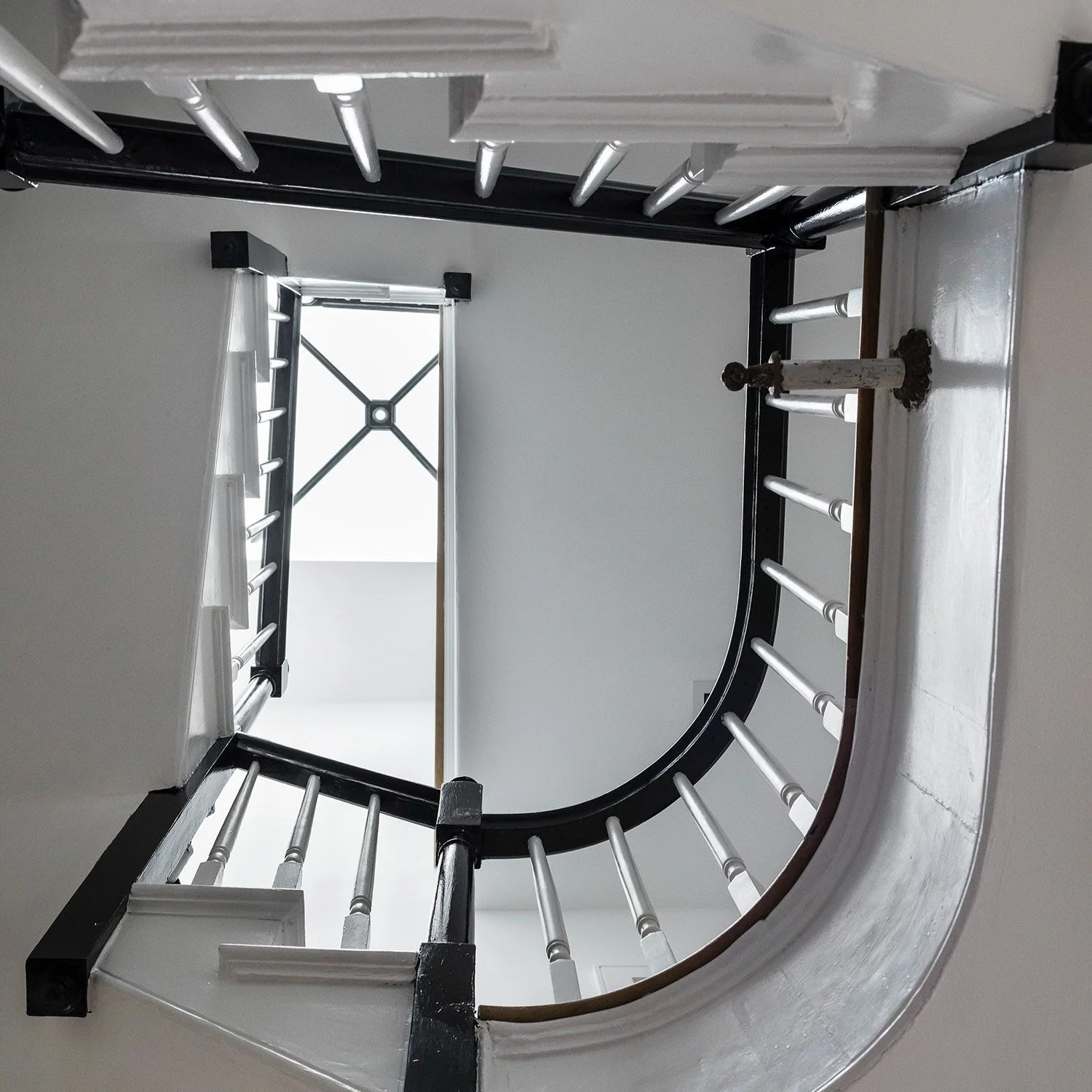 Sculptural spiral staircase seen from below in a South End Boston residence on Clarendon Street by Ivory & Bone Interiors