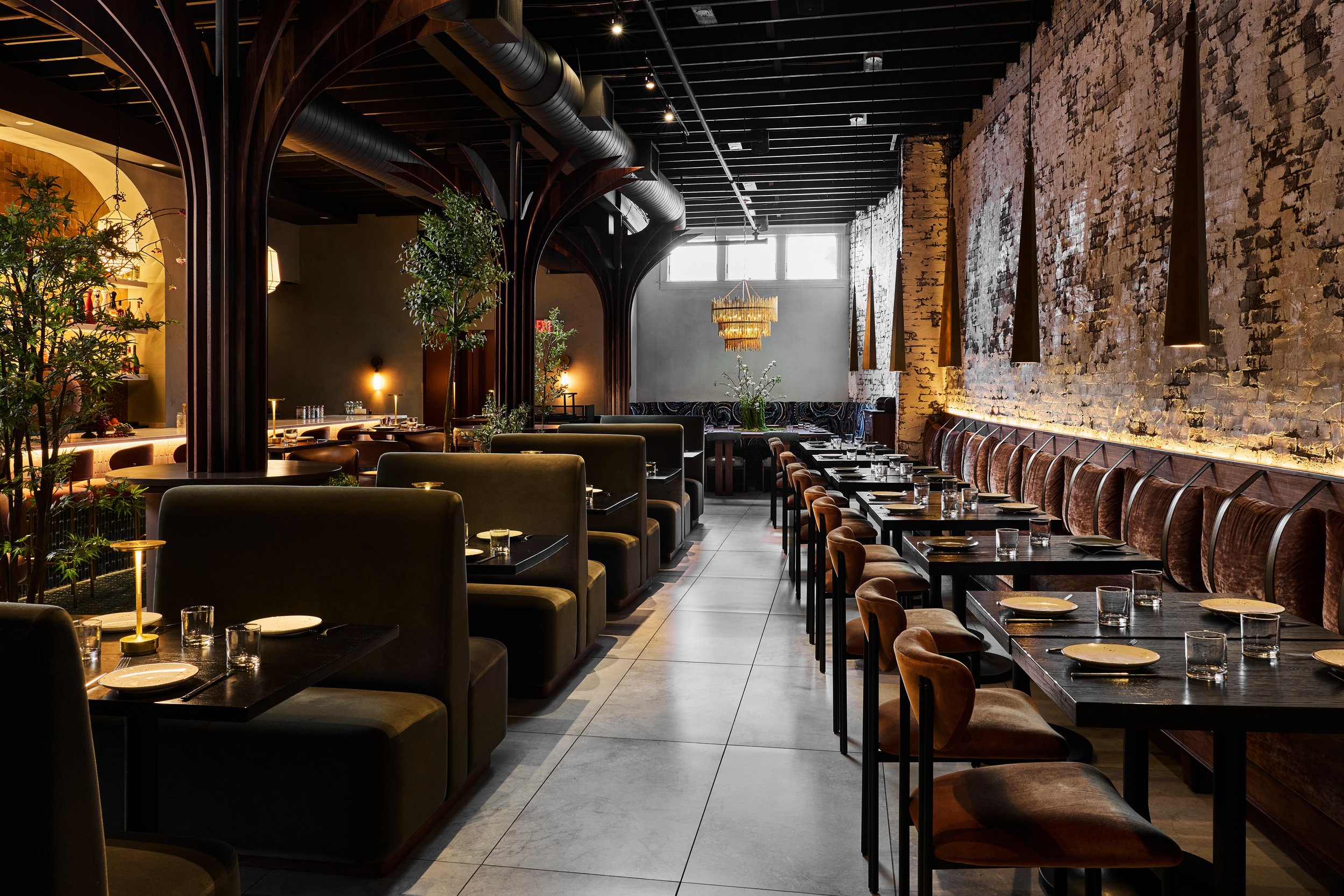 Acapella restaurant dining room in Boston with long banquettes and exposed brick, designed by Ivory & Bone Interiors