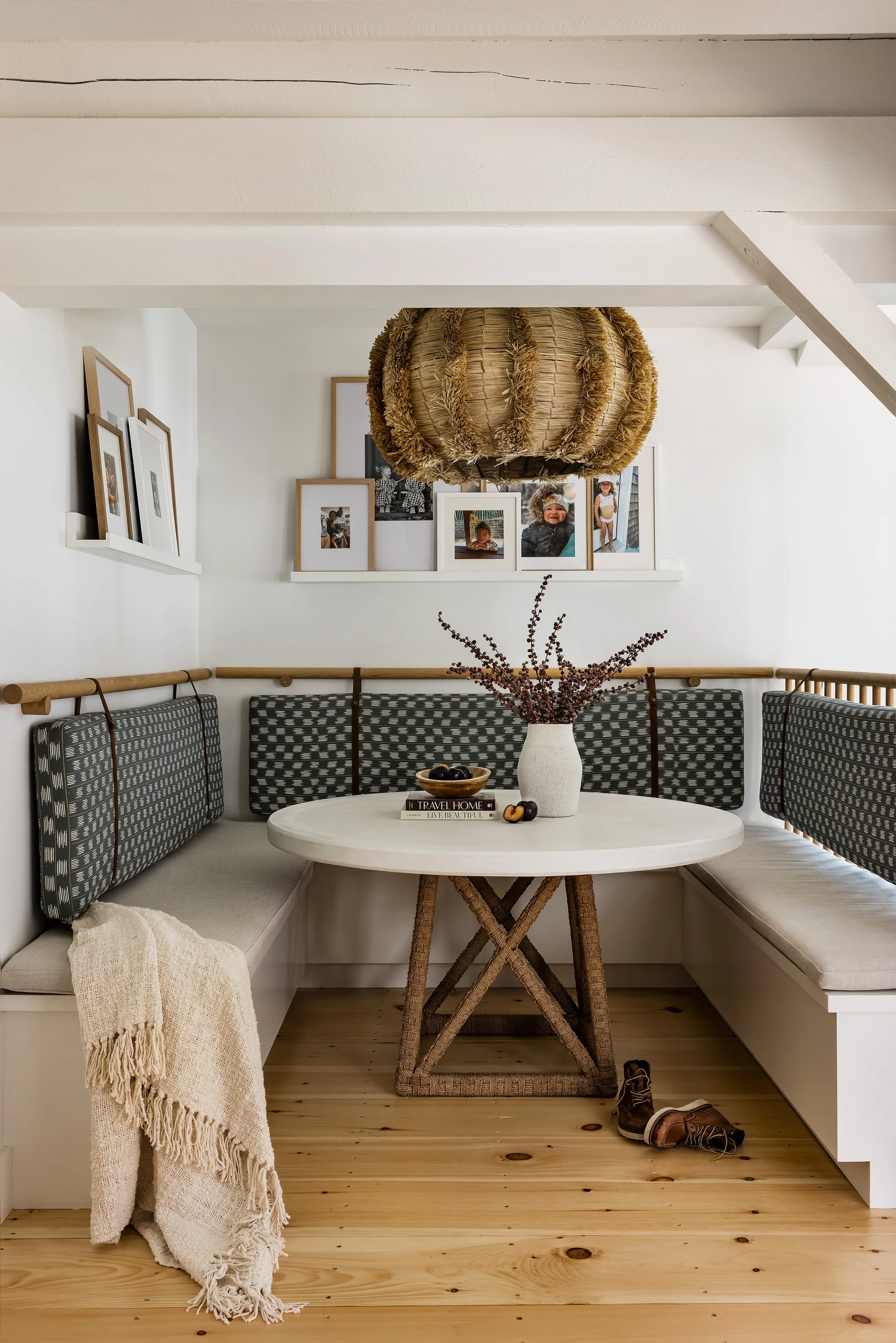 Breakfast nook with built-in banquette, green ikat cushions, family photo ledge and woven grass pendant in a Wild Rose Lane renovation by Ivory & Bone Interiors