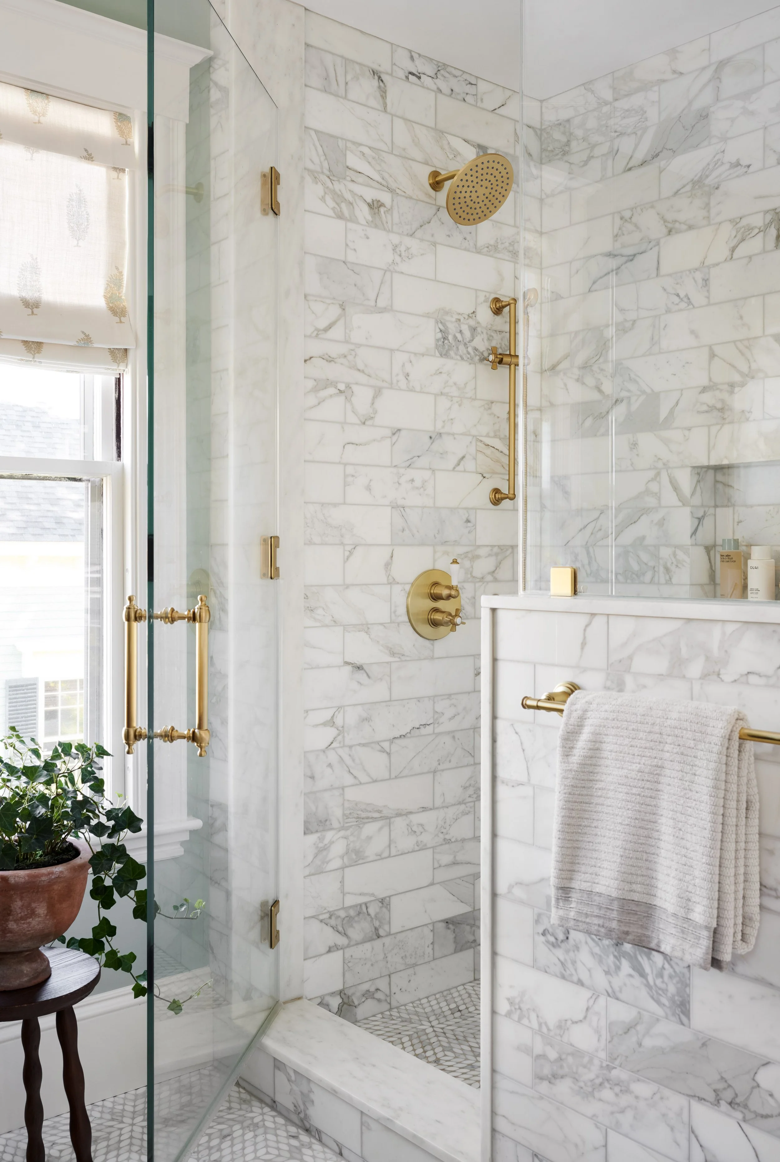 Marble walk-in shower with brass fixtures at Whitmore Road, Newburyport, designed by Ivory & Bone Interiors