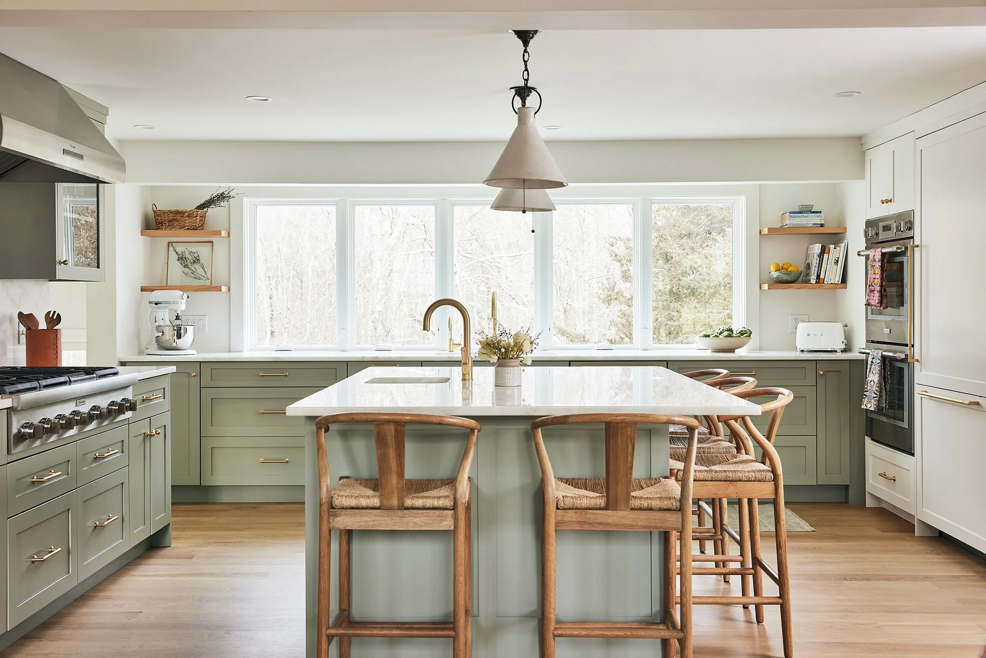 Sage green kitchen with marble island, wishbone counter stools and pendant light at Patriots Way, Rye, NH, designed by Ivory & Bone Interiors