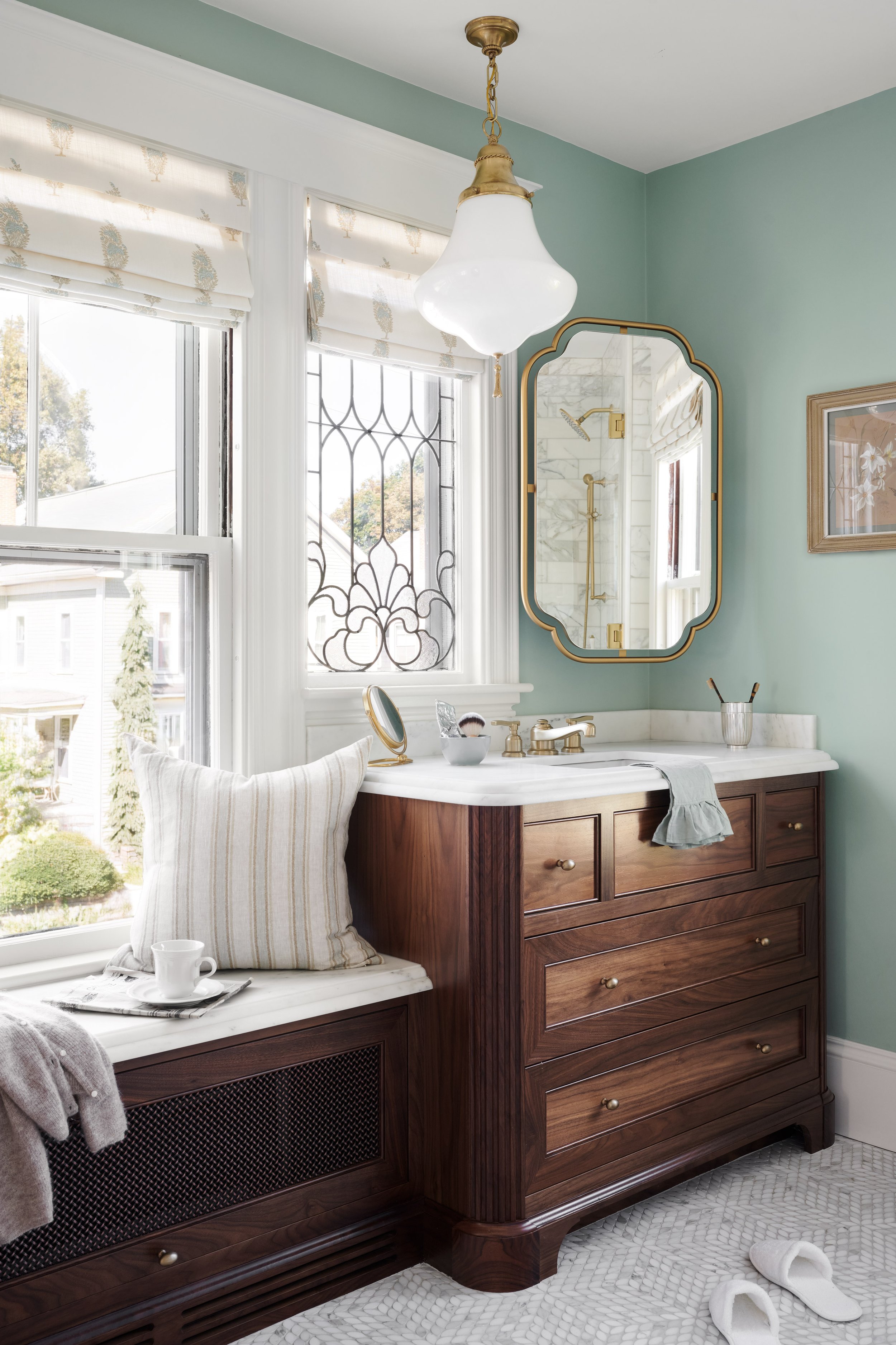 Walnut vanity and window seat beneath a leaded-glass window at Whitmore Road, Newburyport, designed by Ivory & Bone Interiors