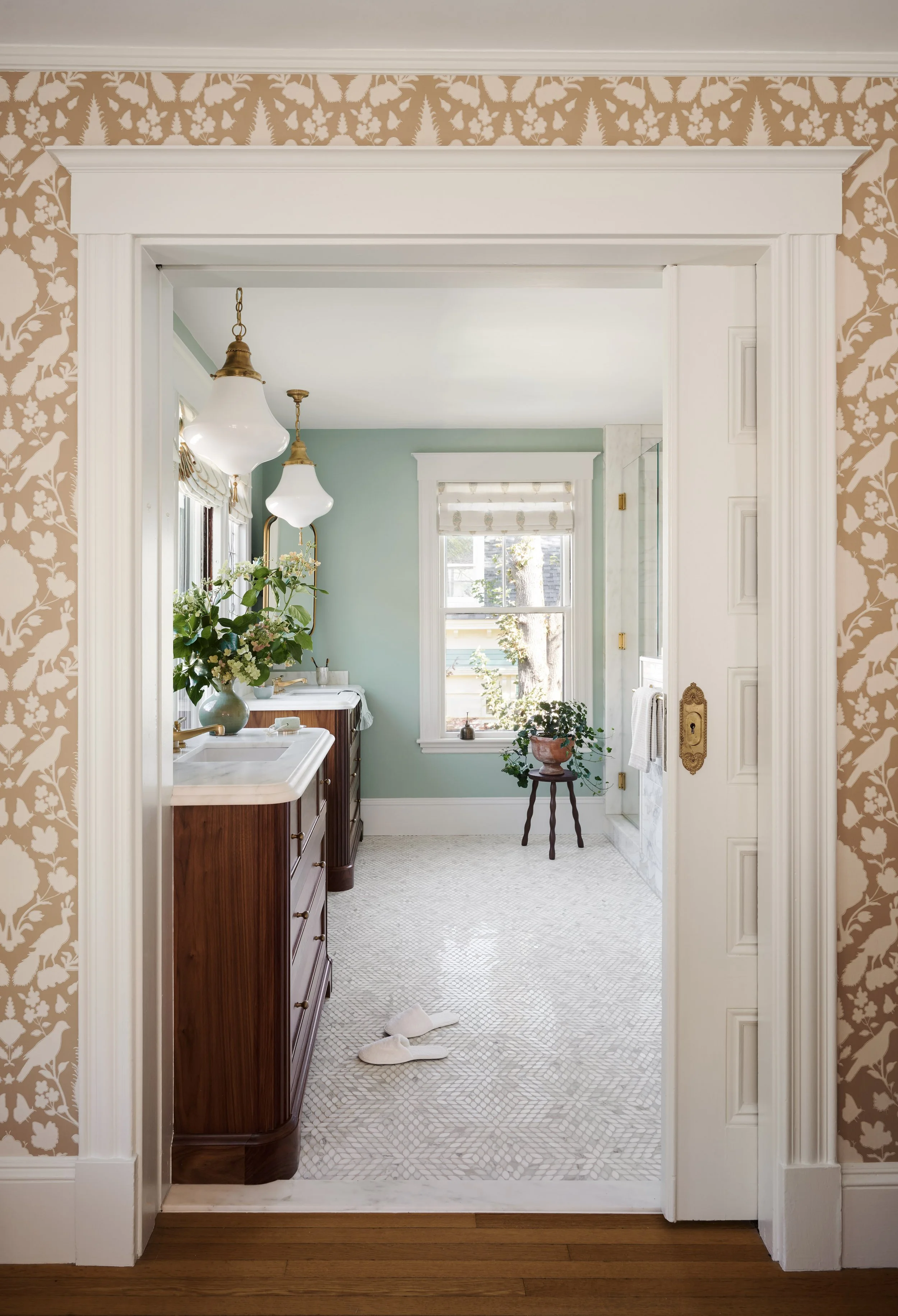Primary bathroom doorway framed in bird-print wallpaper at Whitmore Road, Newburyport, designed by Ivory & Bone Interiors