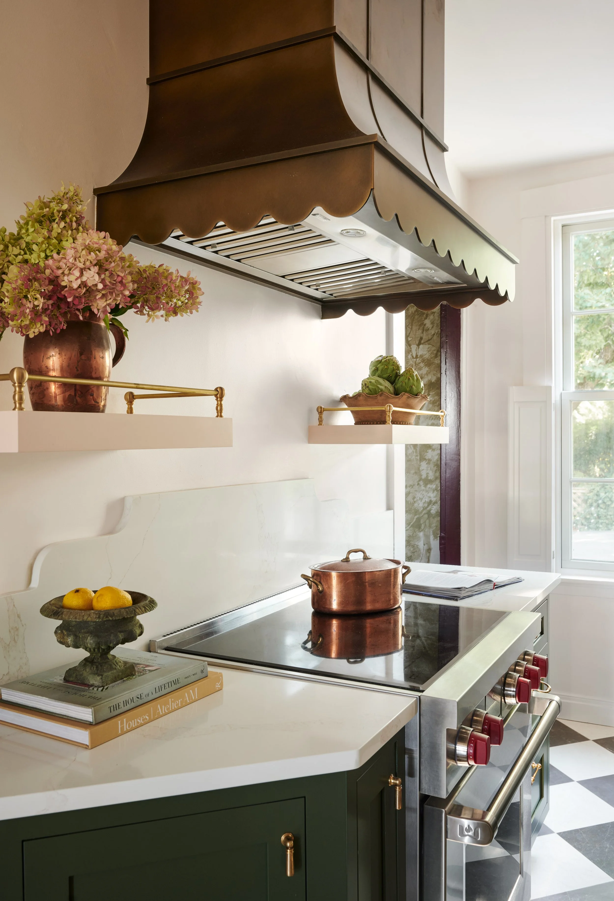Scalloped brass range hood over an induction range with copper pot at Summer Street, Newburyport, designed by Ivory & Bone Interiors
